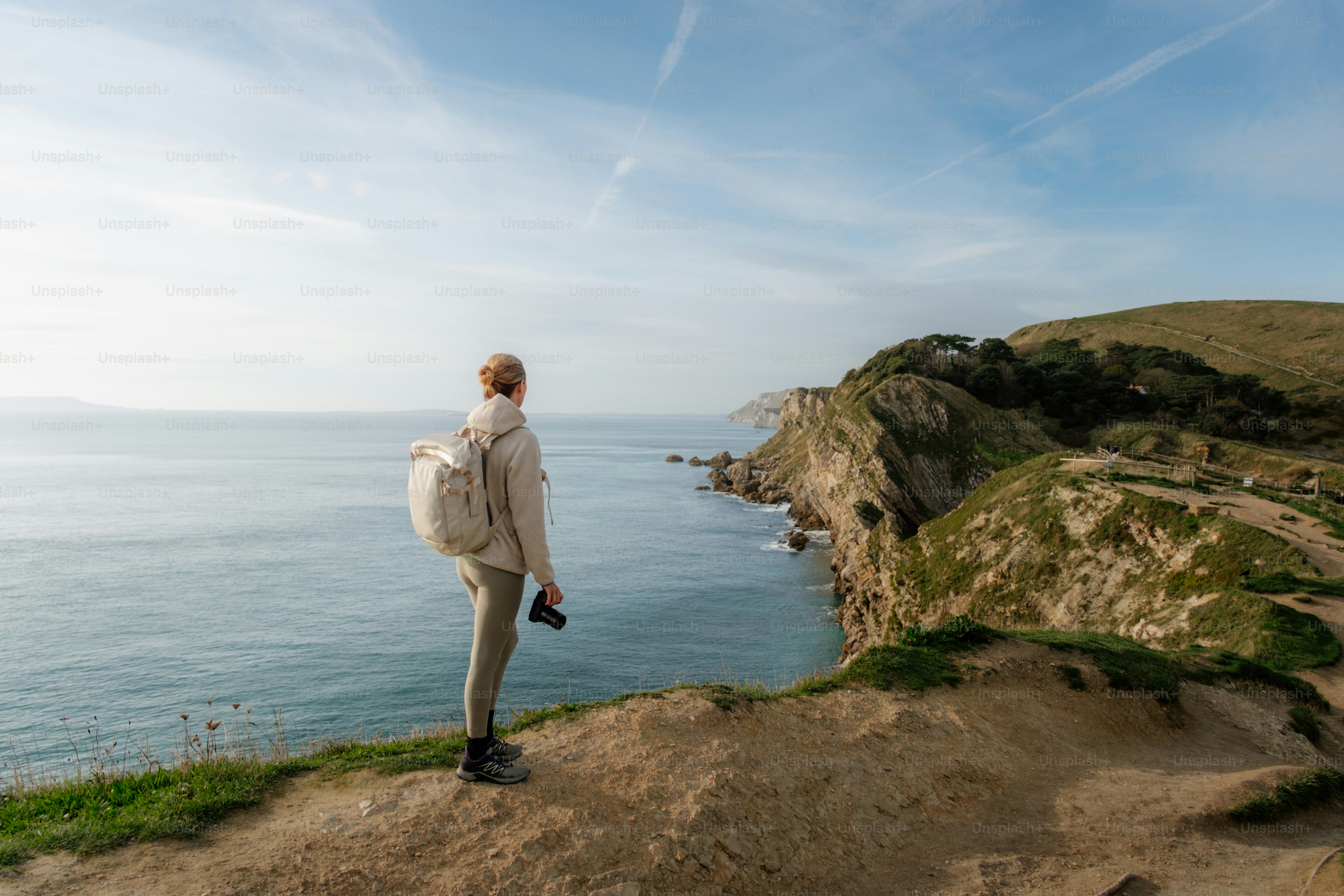 A person standing on a cliff overlooking the ocean