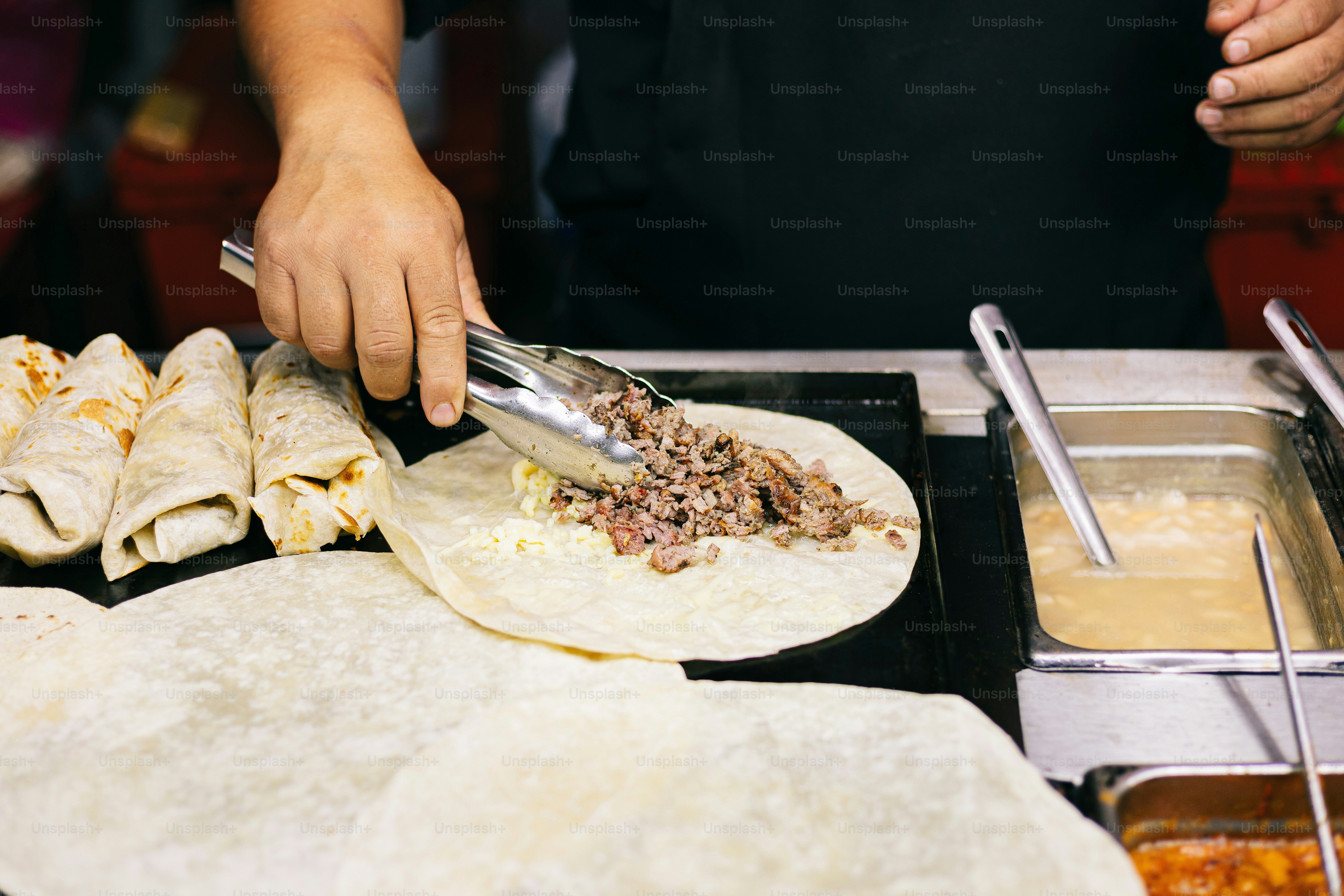 A person cutting a tortilla with a knife