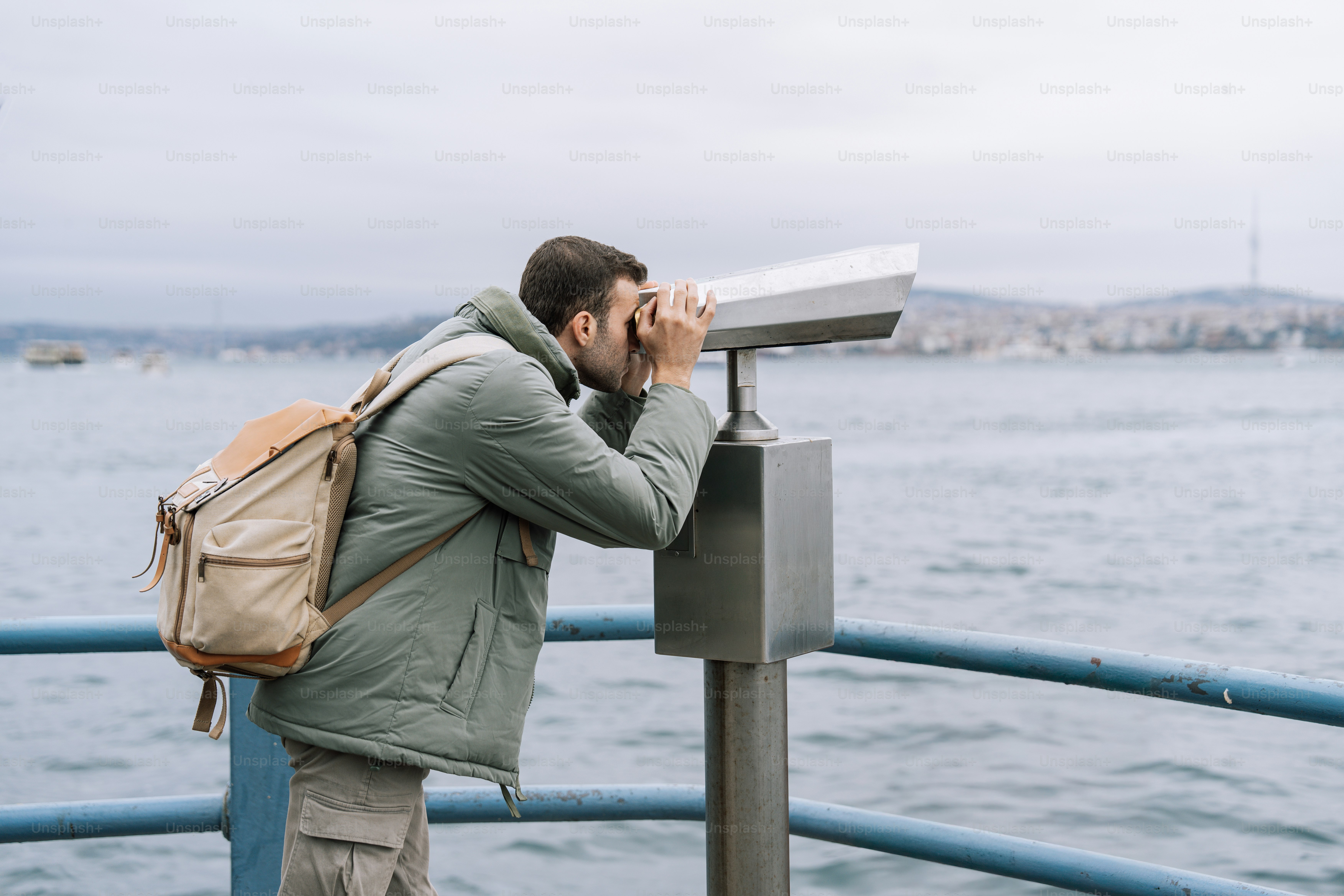 A man sitting on a bench in front of a building photo – Green Image on ...