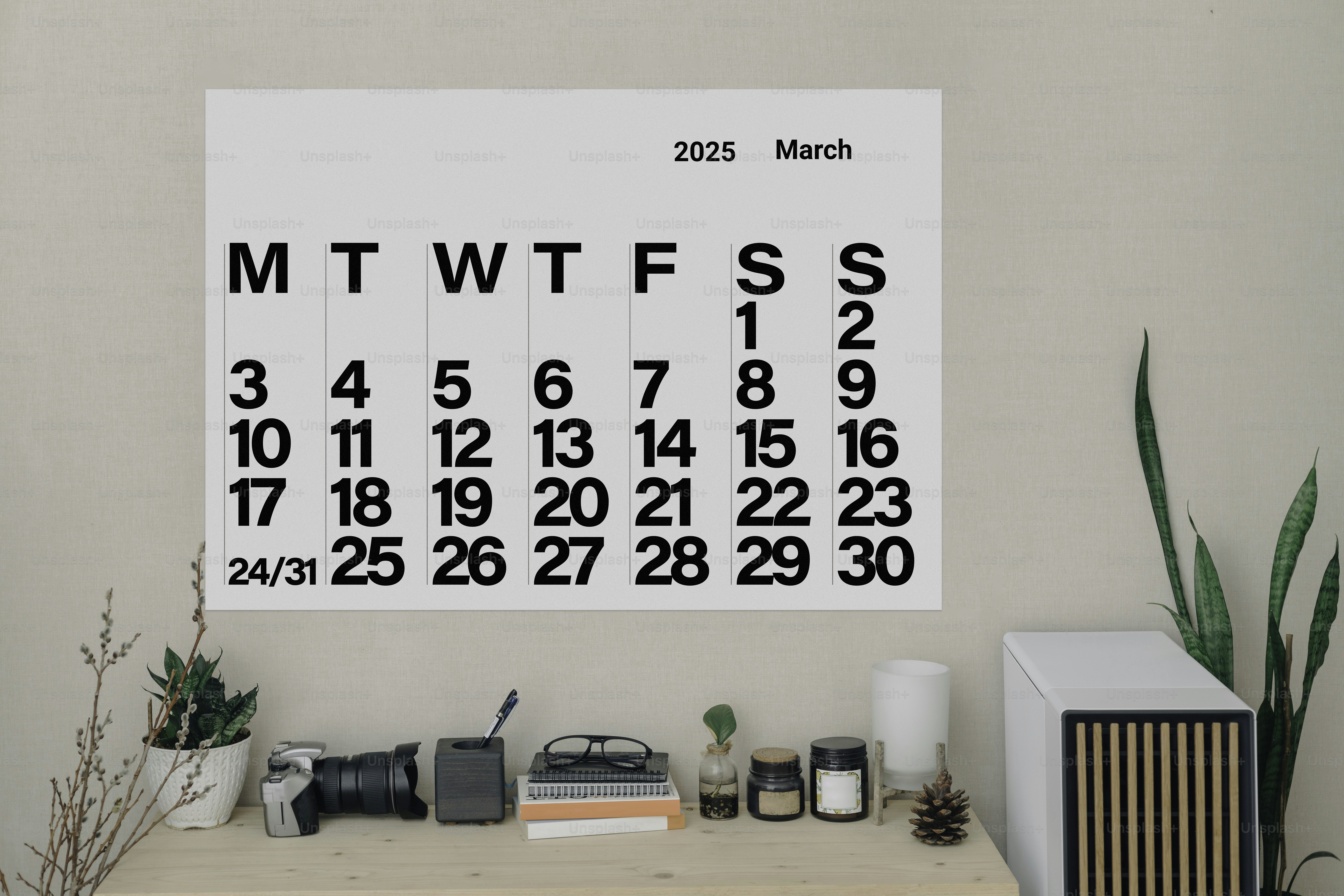 A desk with a calendar hanging on the wall