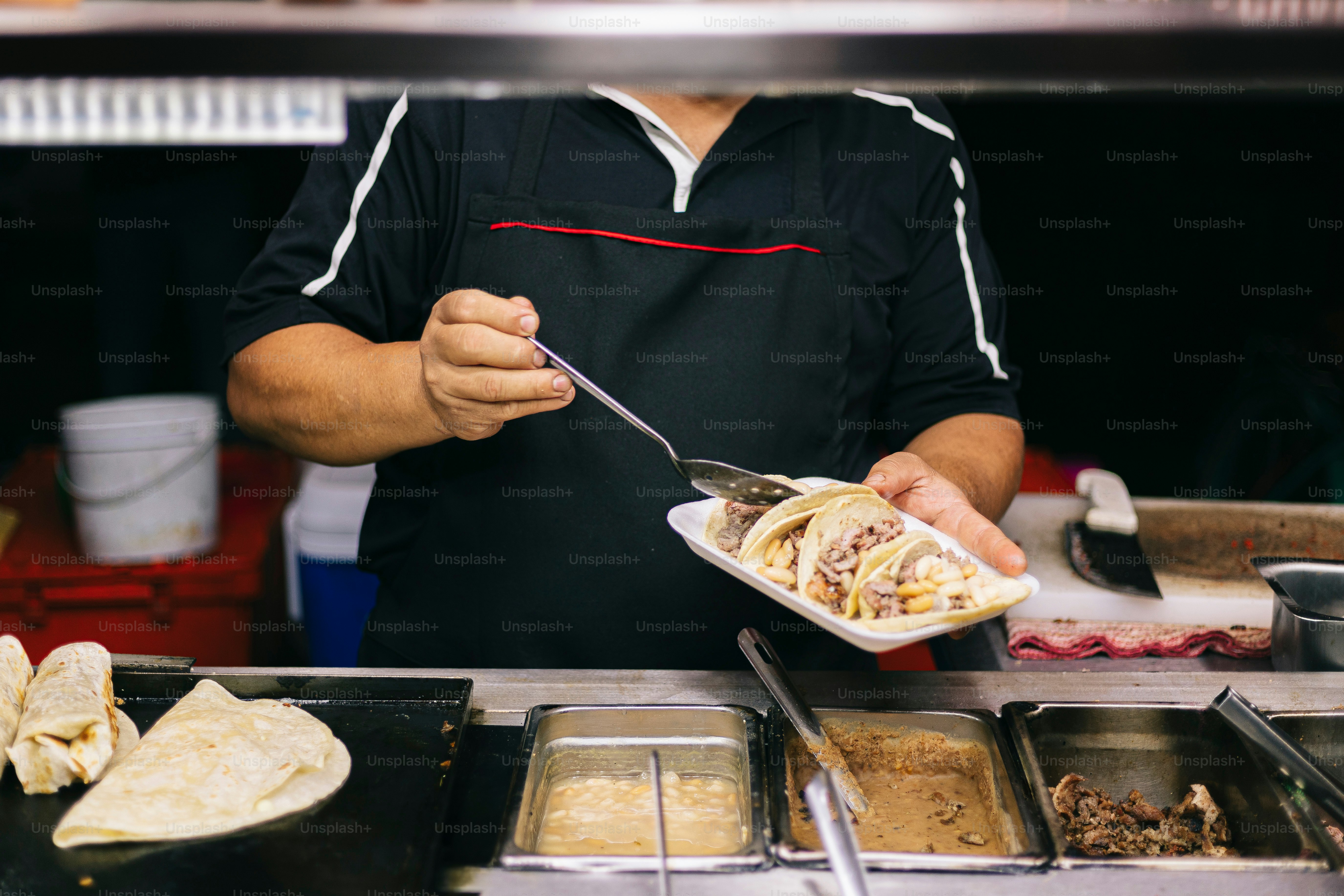 A man holding a plate of food in a kitchen