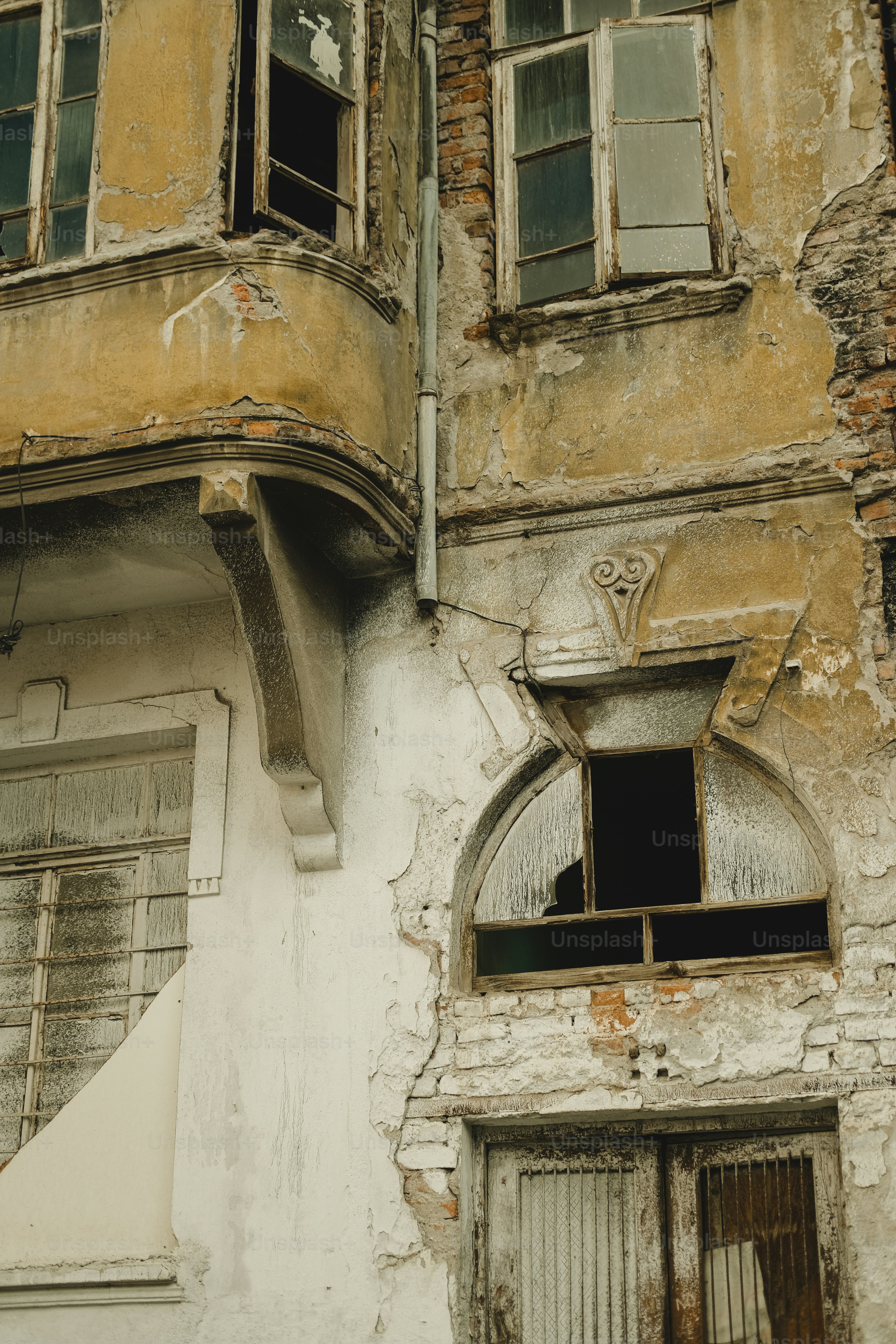 Un vecchio edificio con una finestra rotta e persiane
