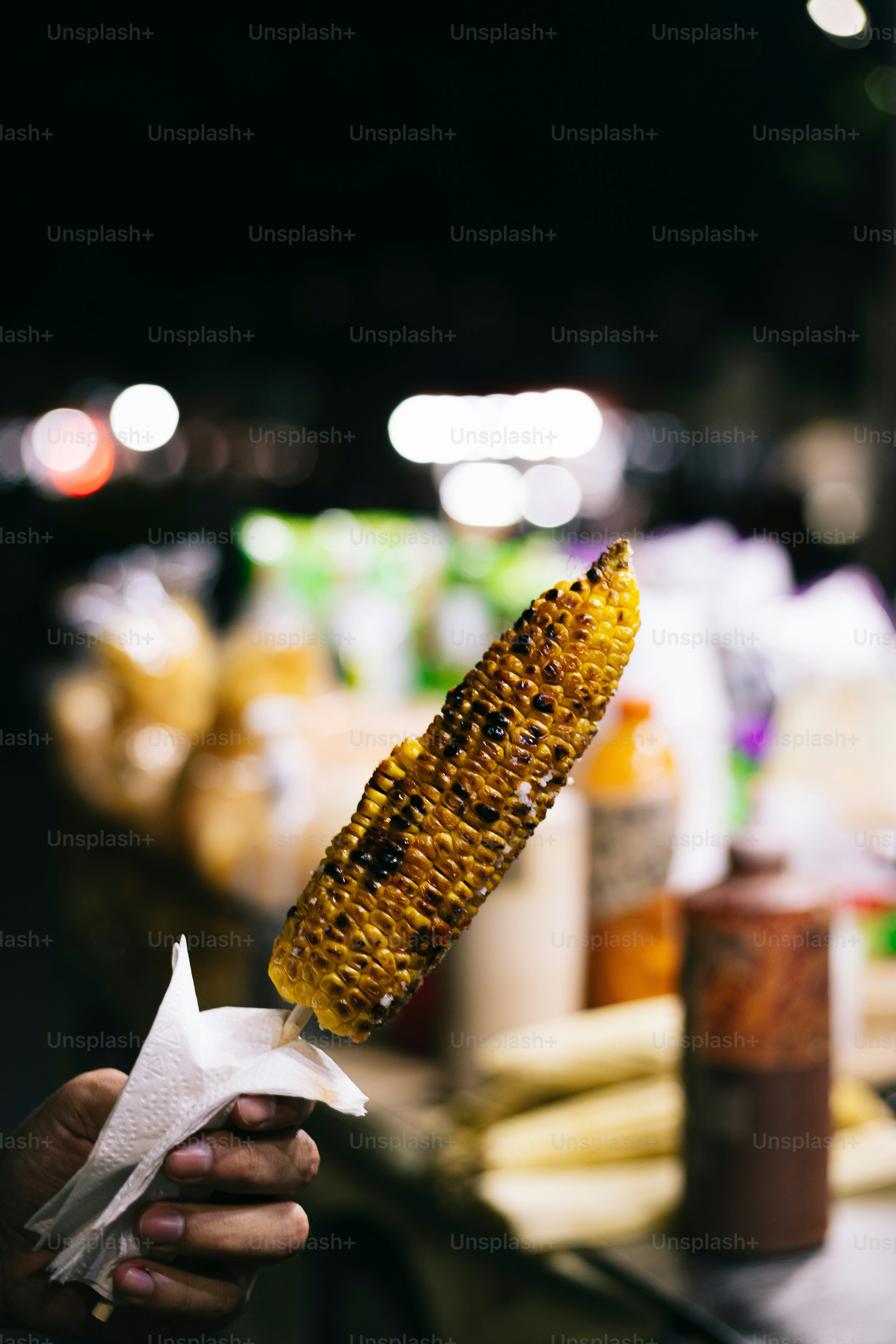 A person holding a corn on the cob