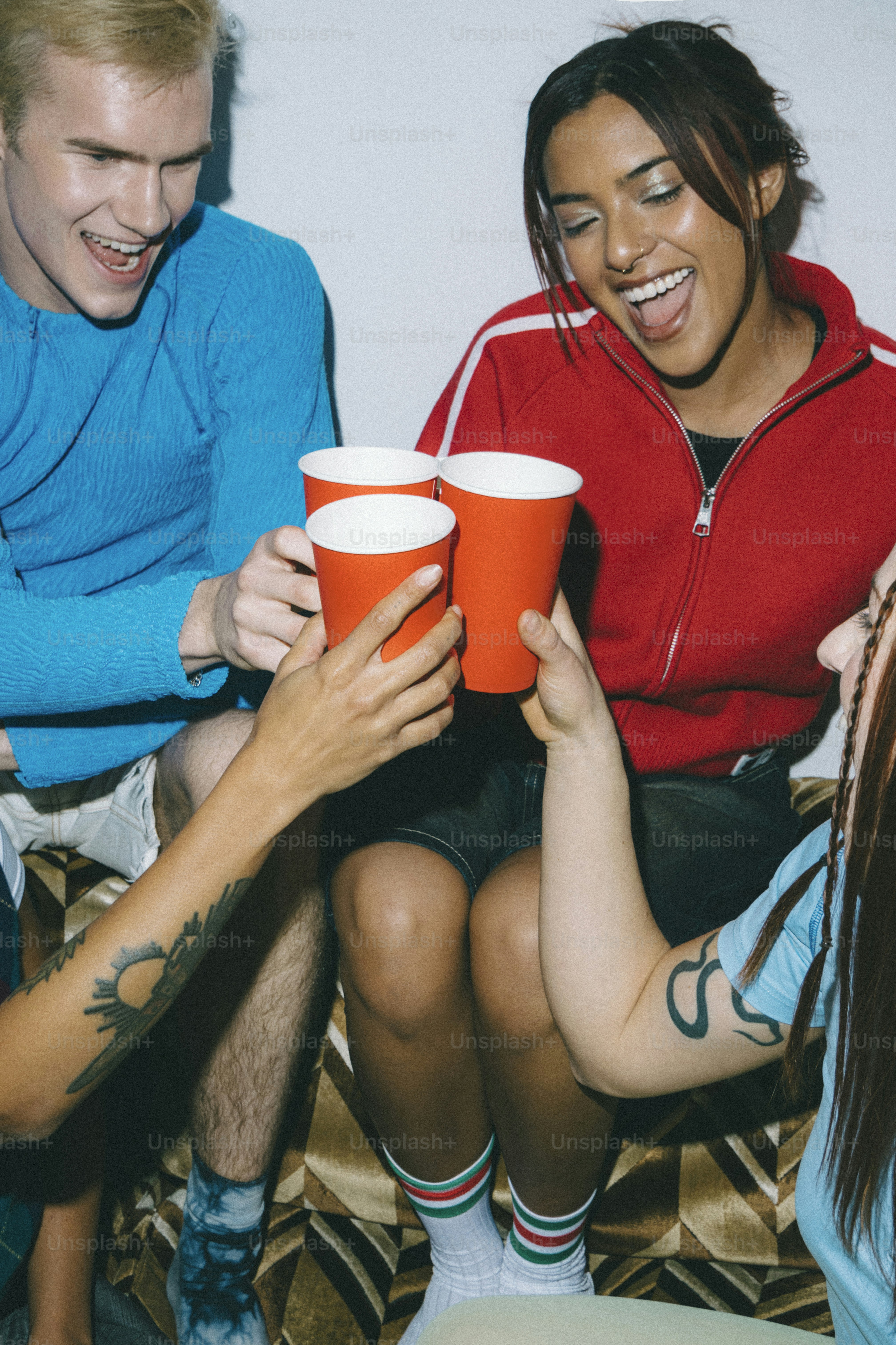 A group of people sitting around each other holding cups
