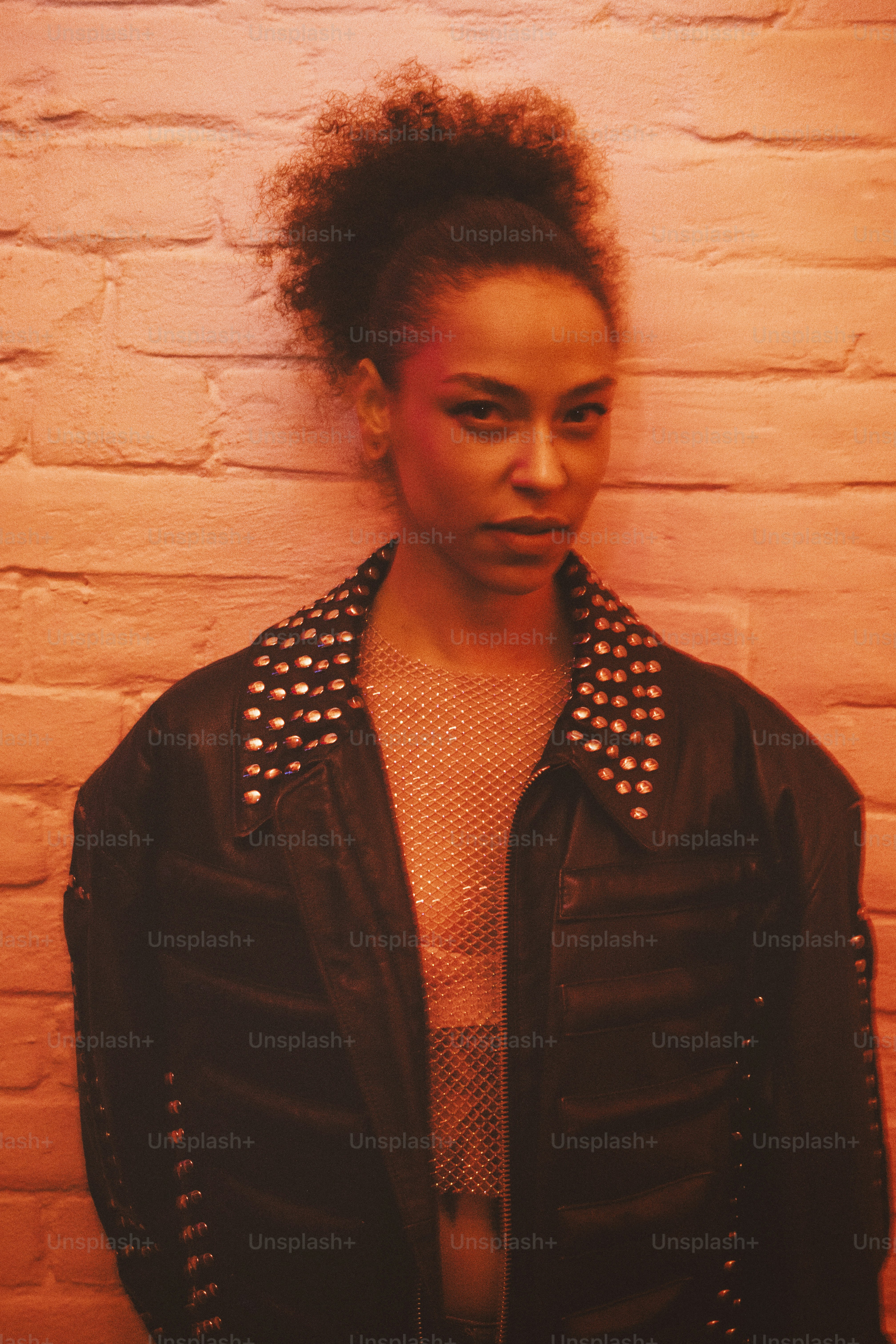 A woman standing in front of a brick wall