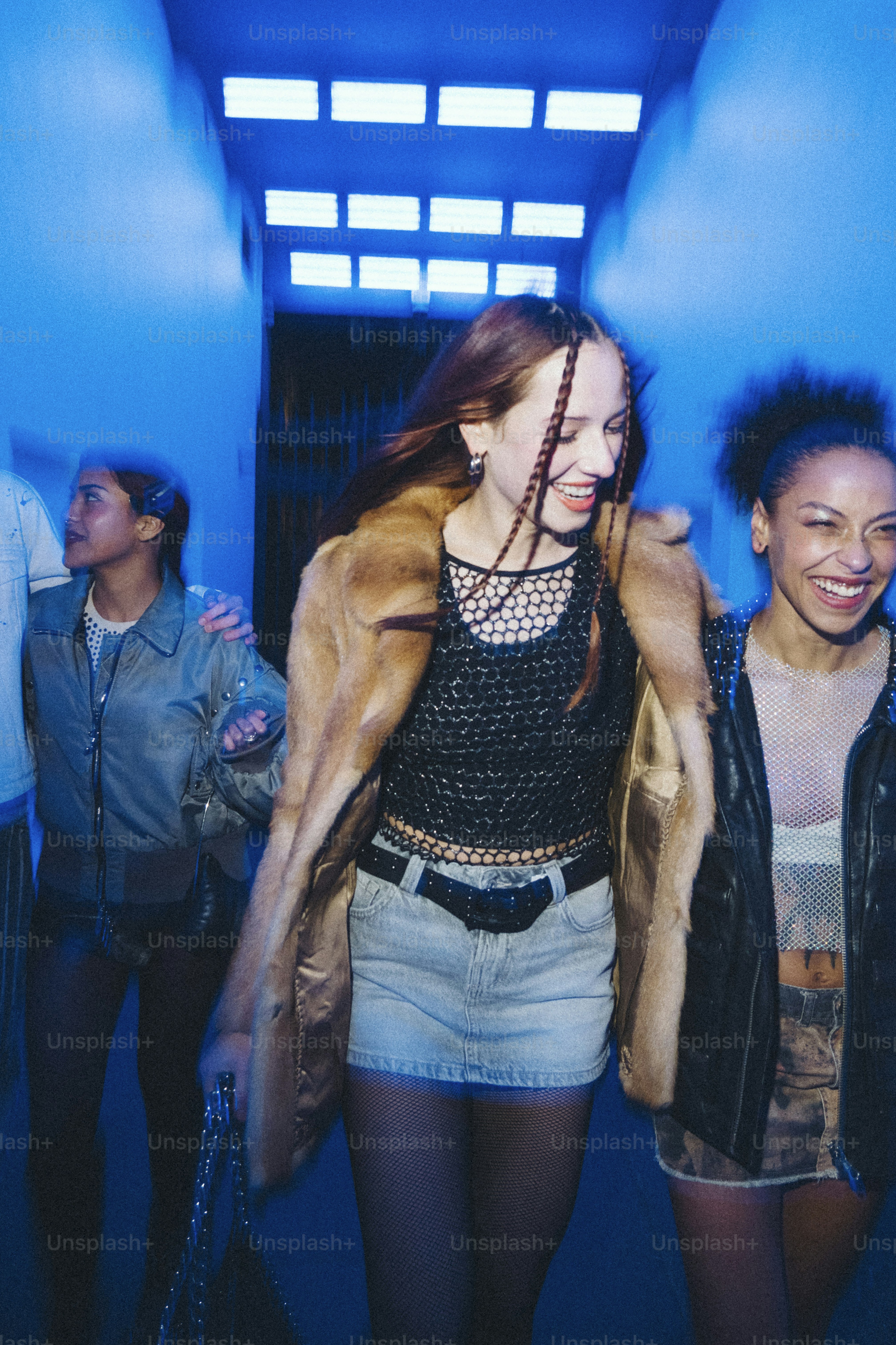 A group of young women walking down a hallway