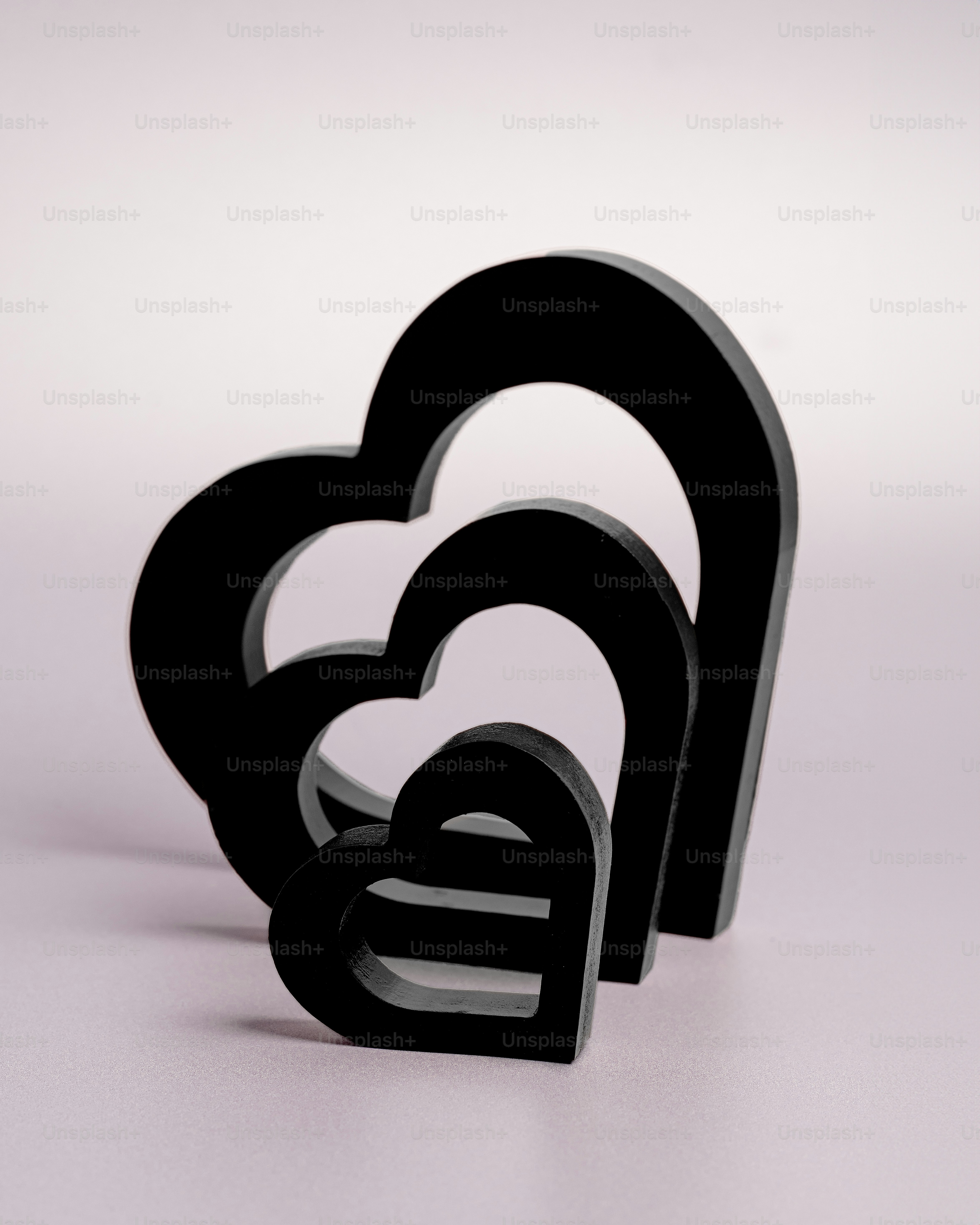 Un par de objetos negros en forma de corazón sobre una superficie blanca