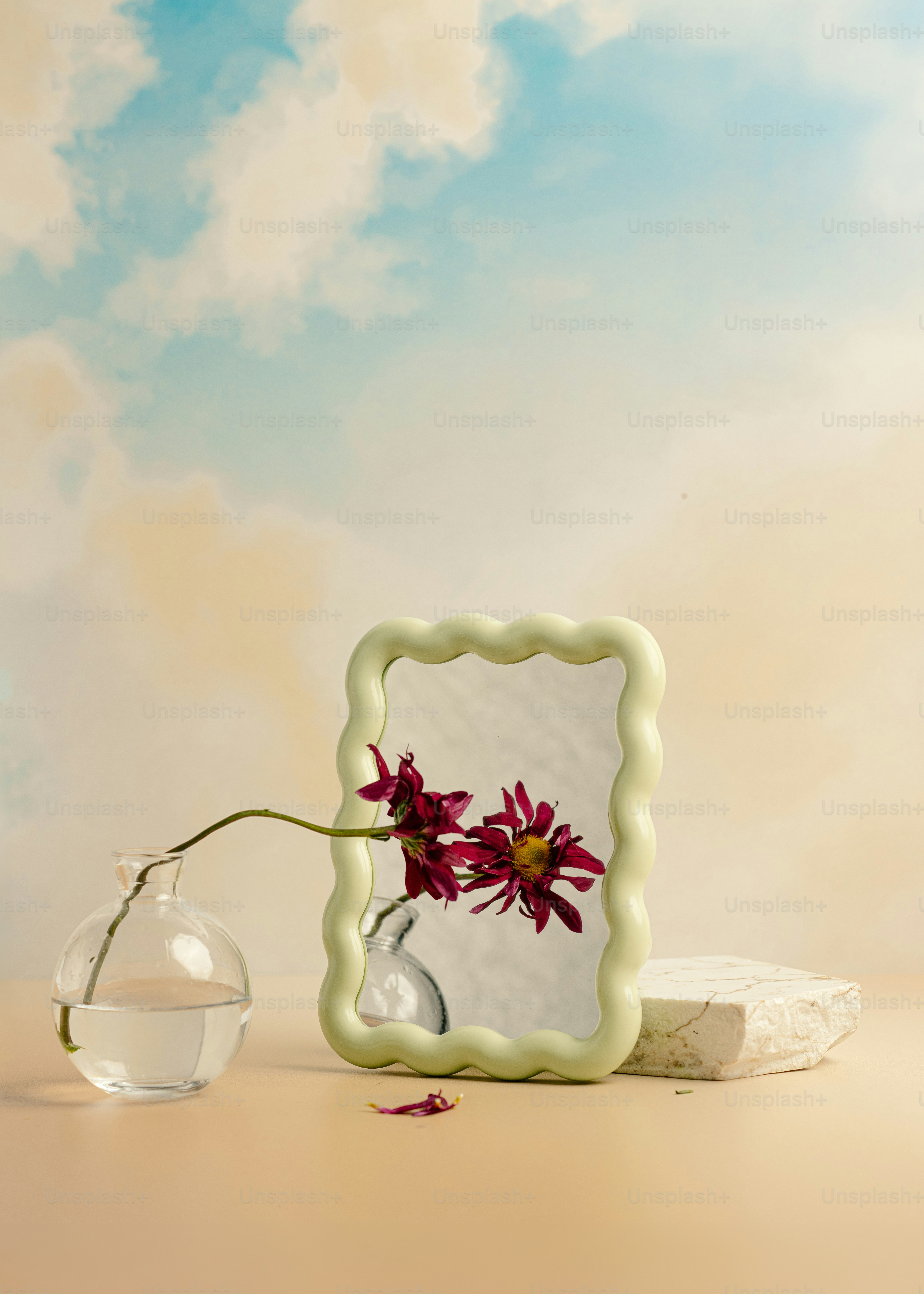 A vase with a flower in it next to a picture frame