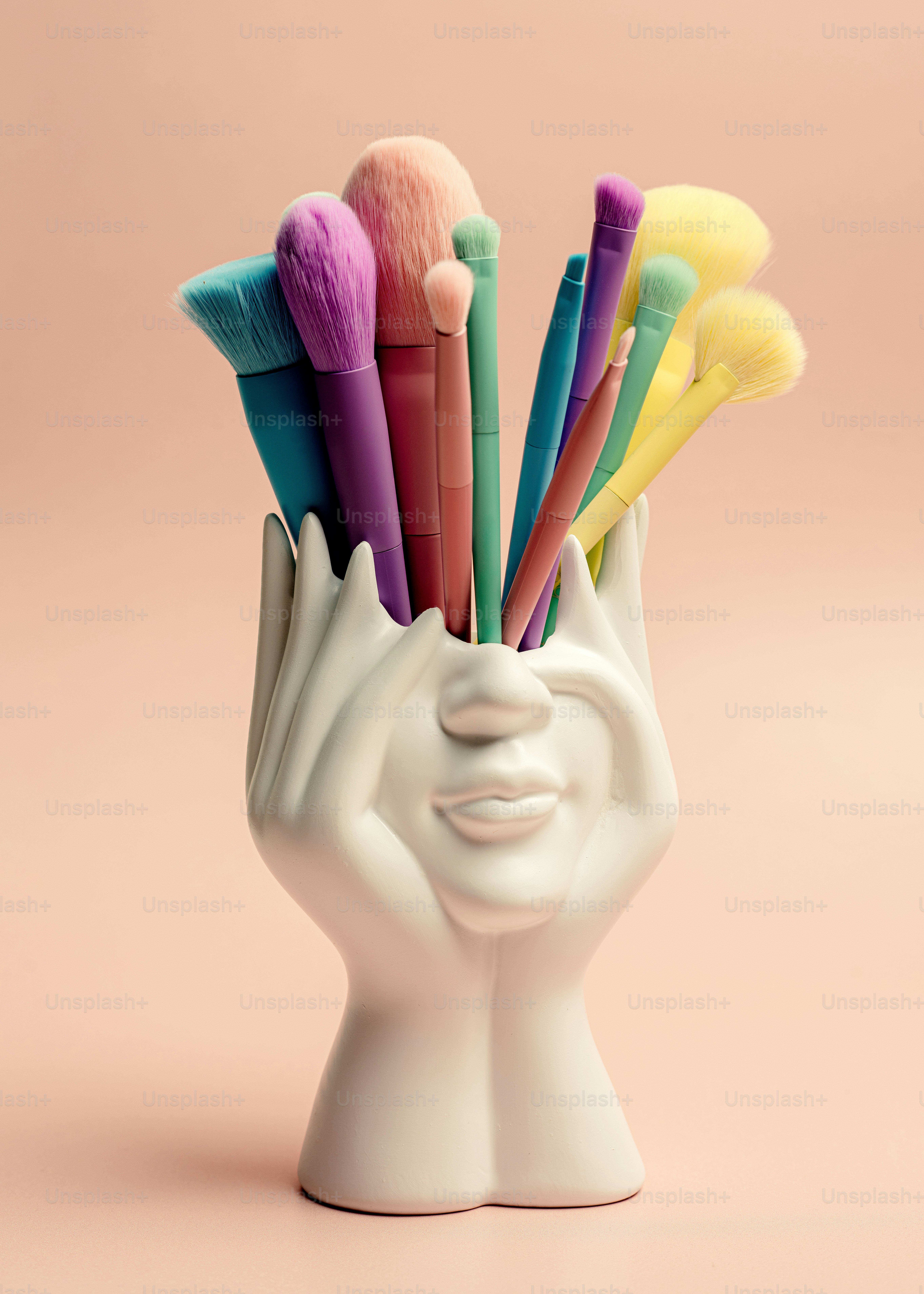 Um vaso branco com um monte de pincéis de cores diferentes