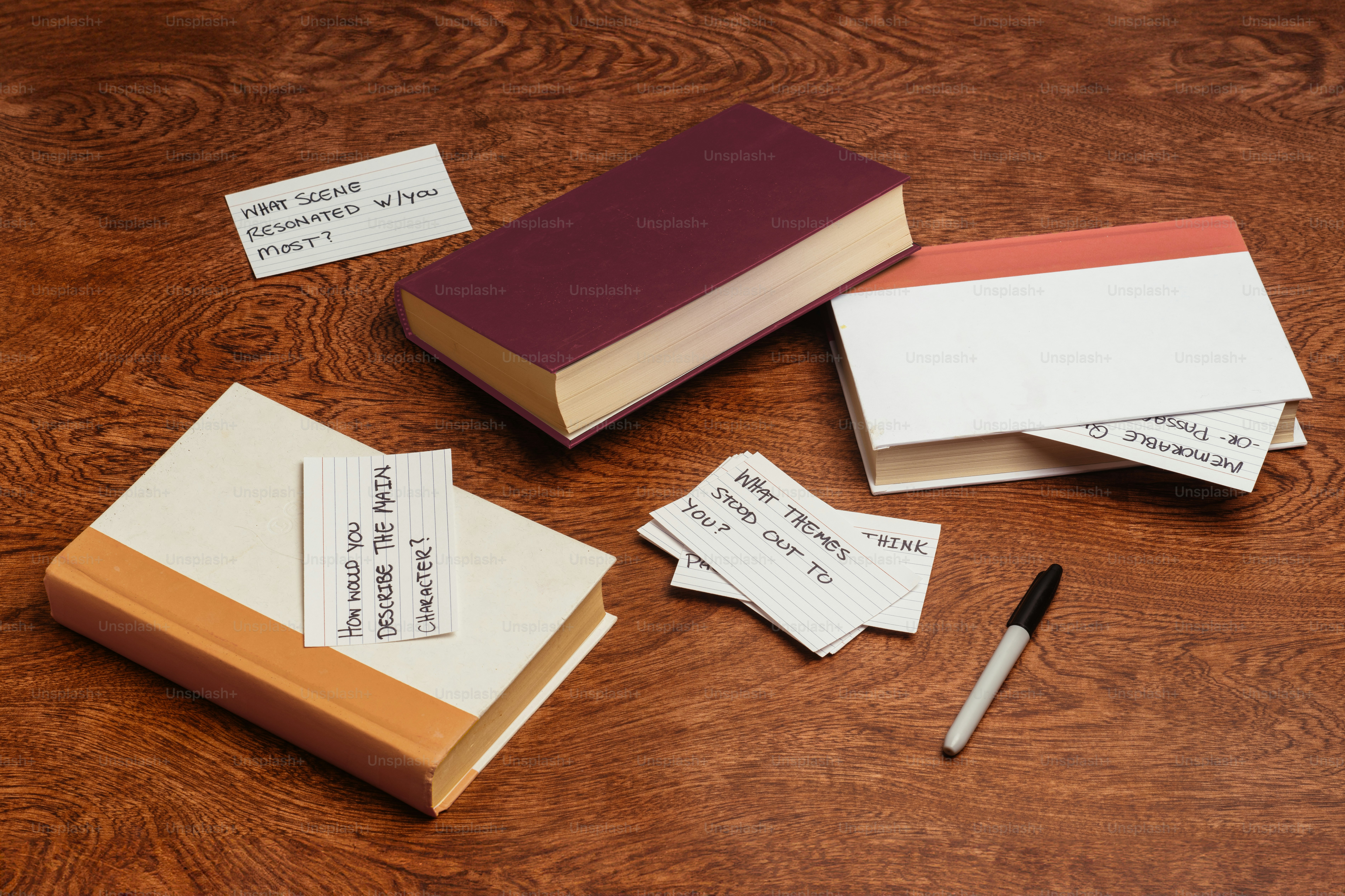 A wooden table topped with lots of books and papers
