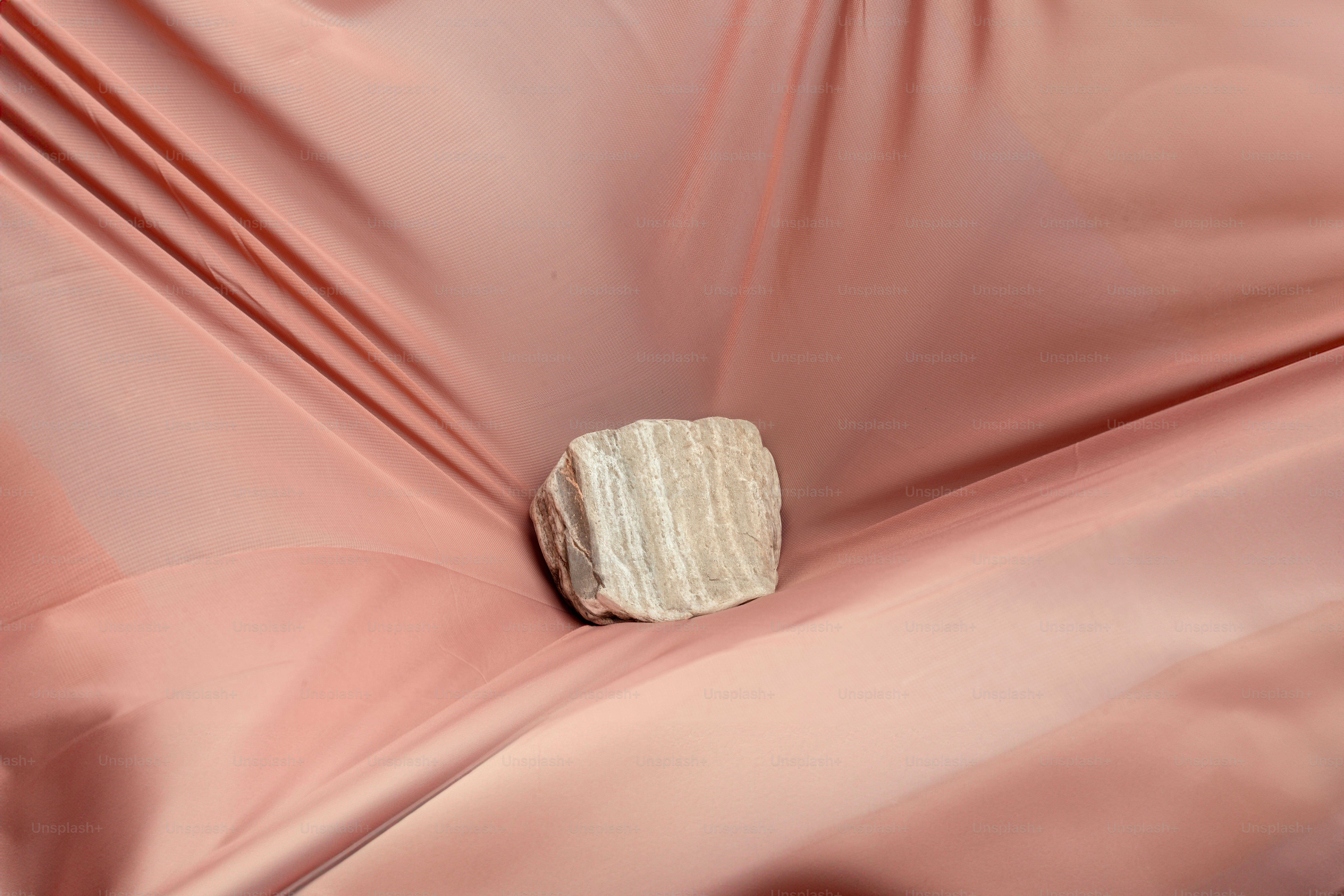 A rock sitting on top of a pink cloth