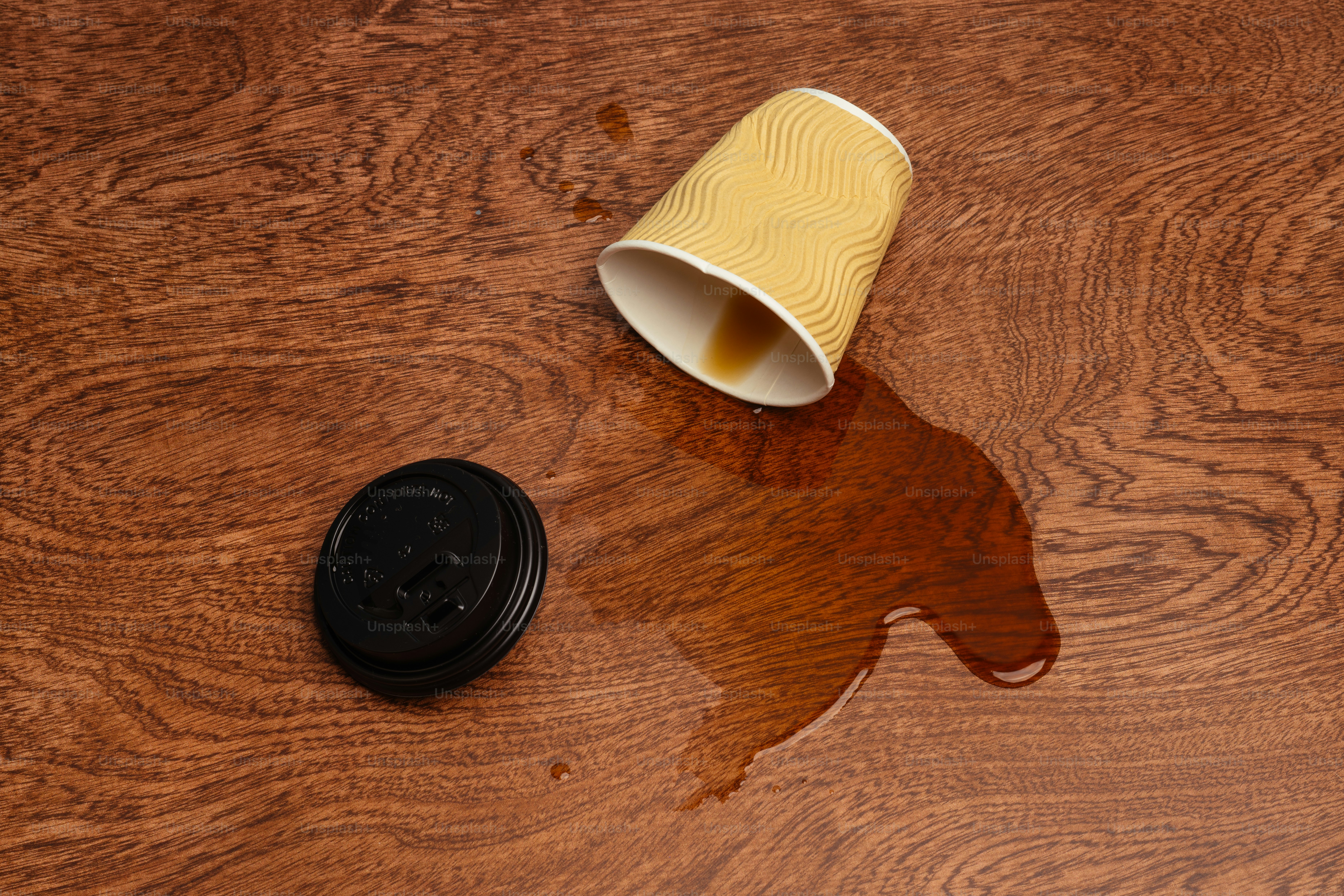 Una tazza di caffè rovesciata su un tavolo di legno