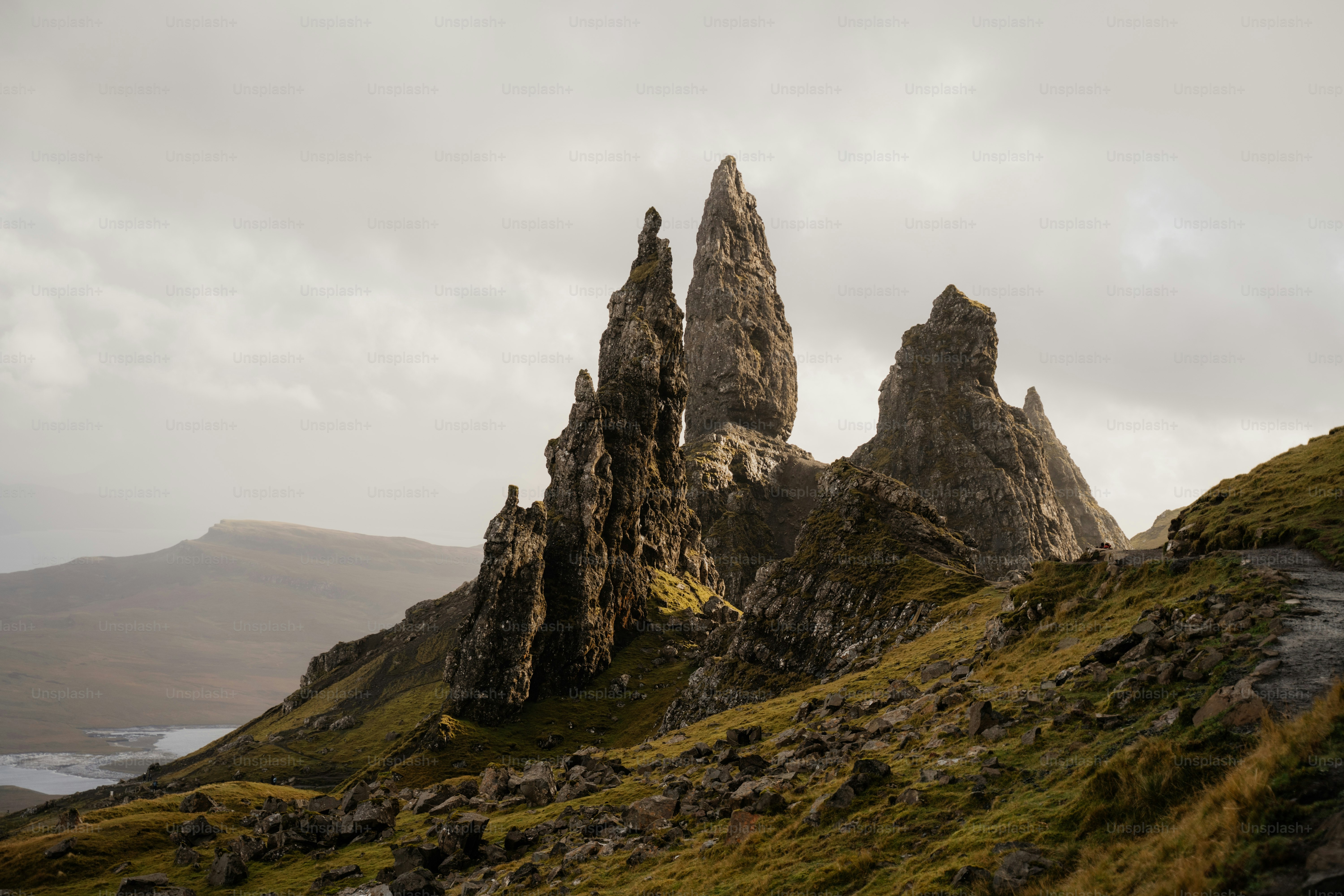 A group of rocks sitting on top of a lush green hillside