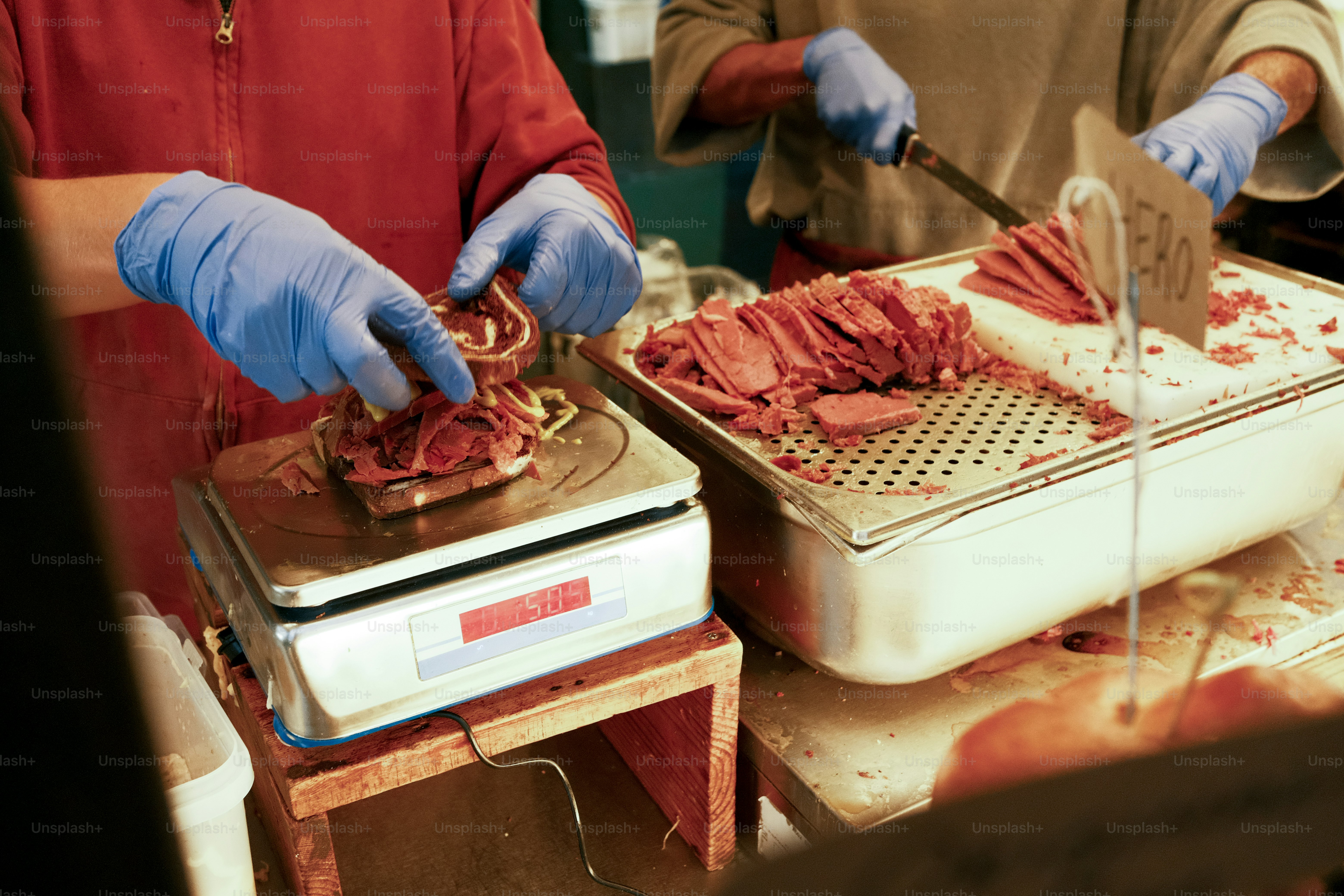A man and a woman cutting meat on a cutting board