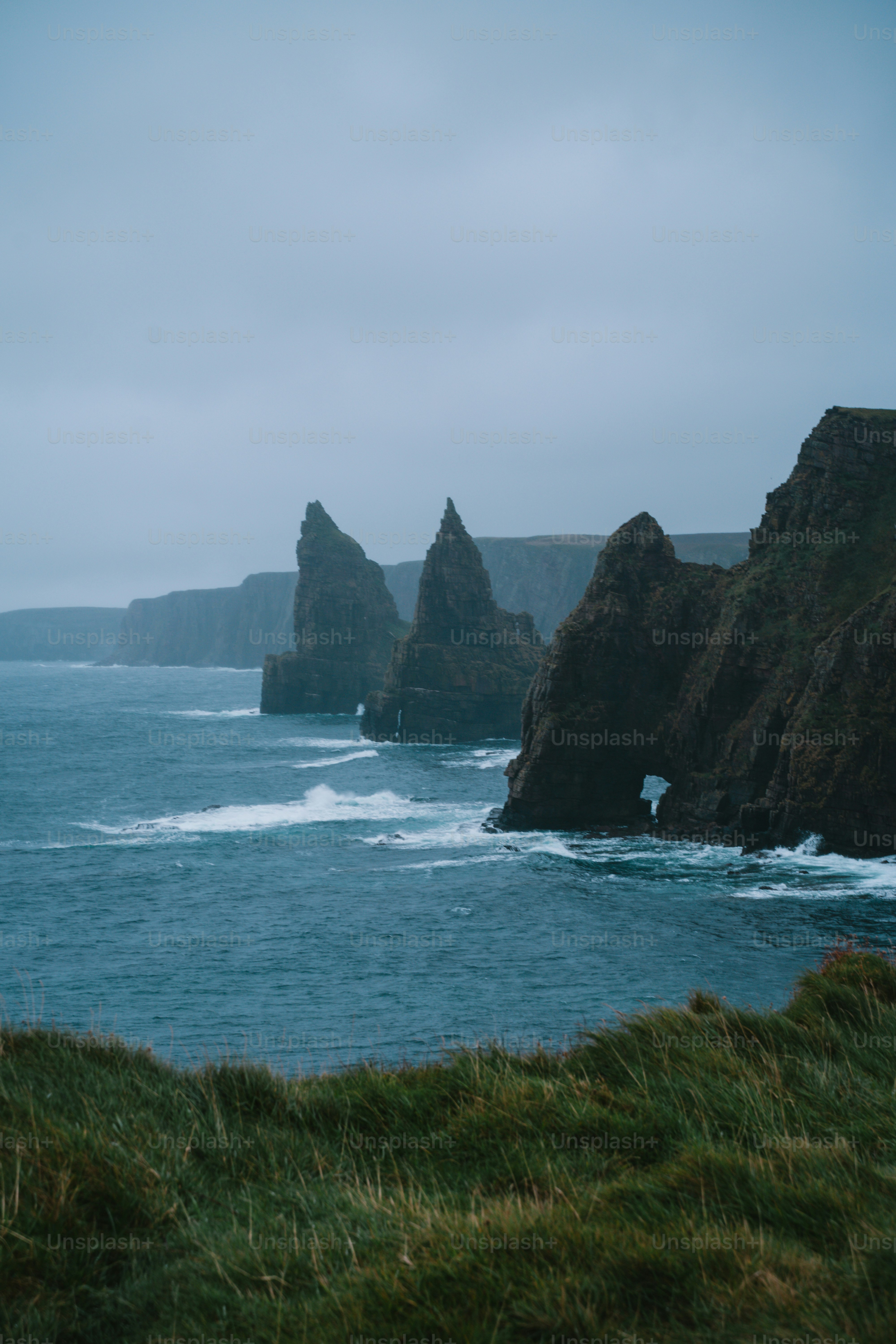 A body of water surrounded by rocks and grass