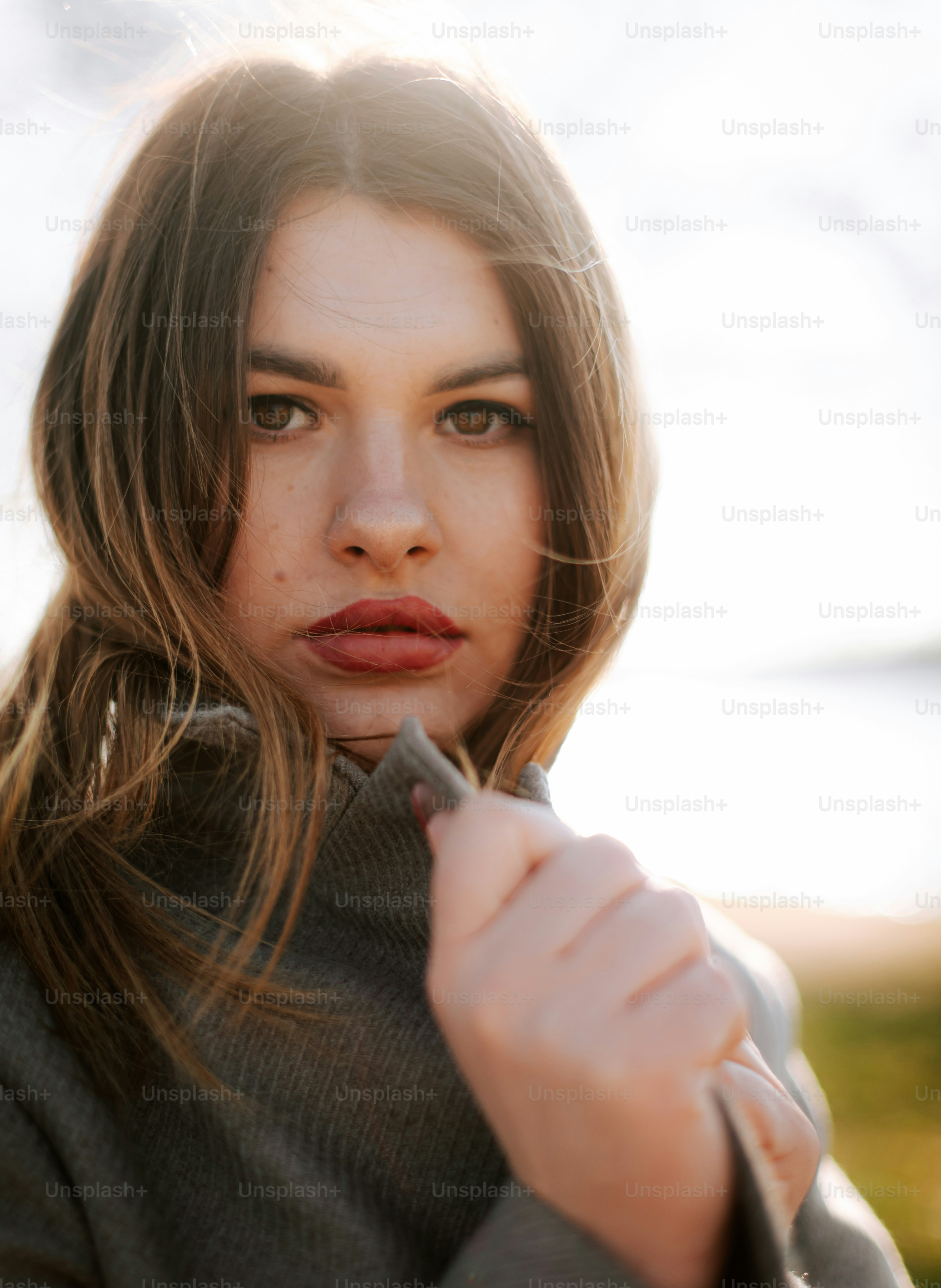 A woman with long hair is holding a cell phone