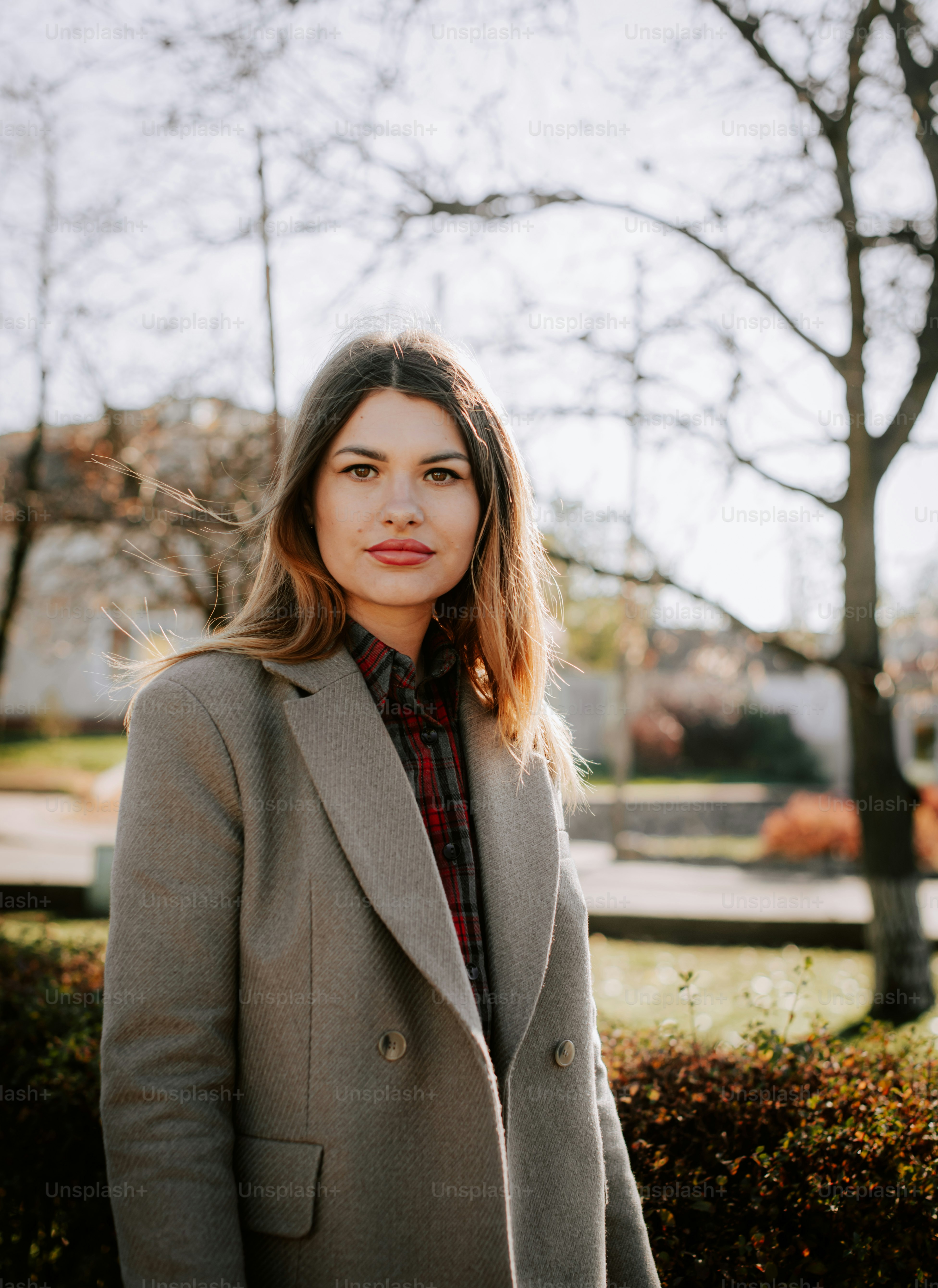 A woman standing in front of a hedge