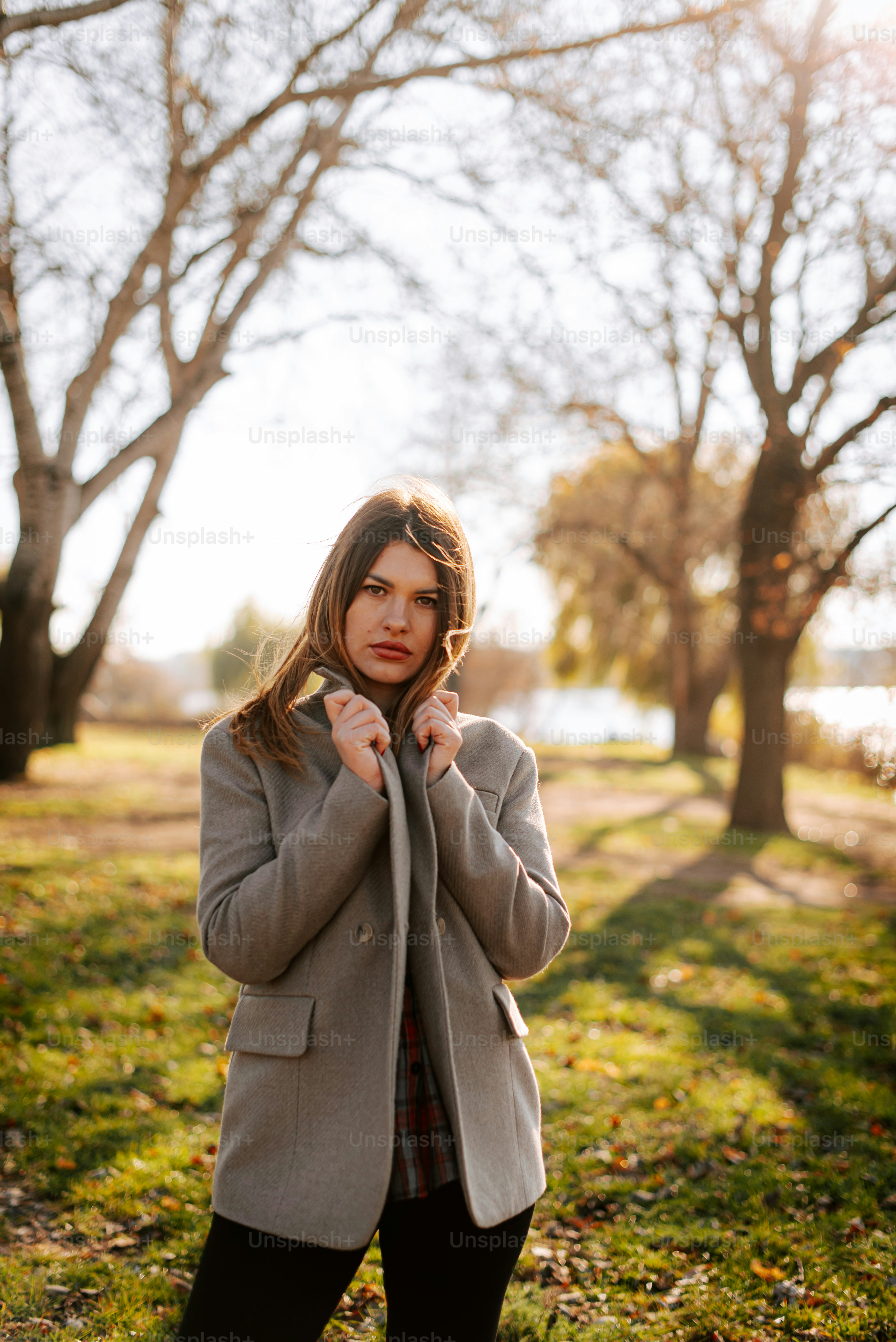 A woman standing in a field with trees in the background