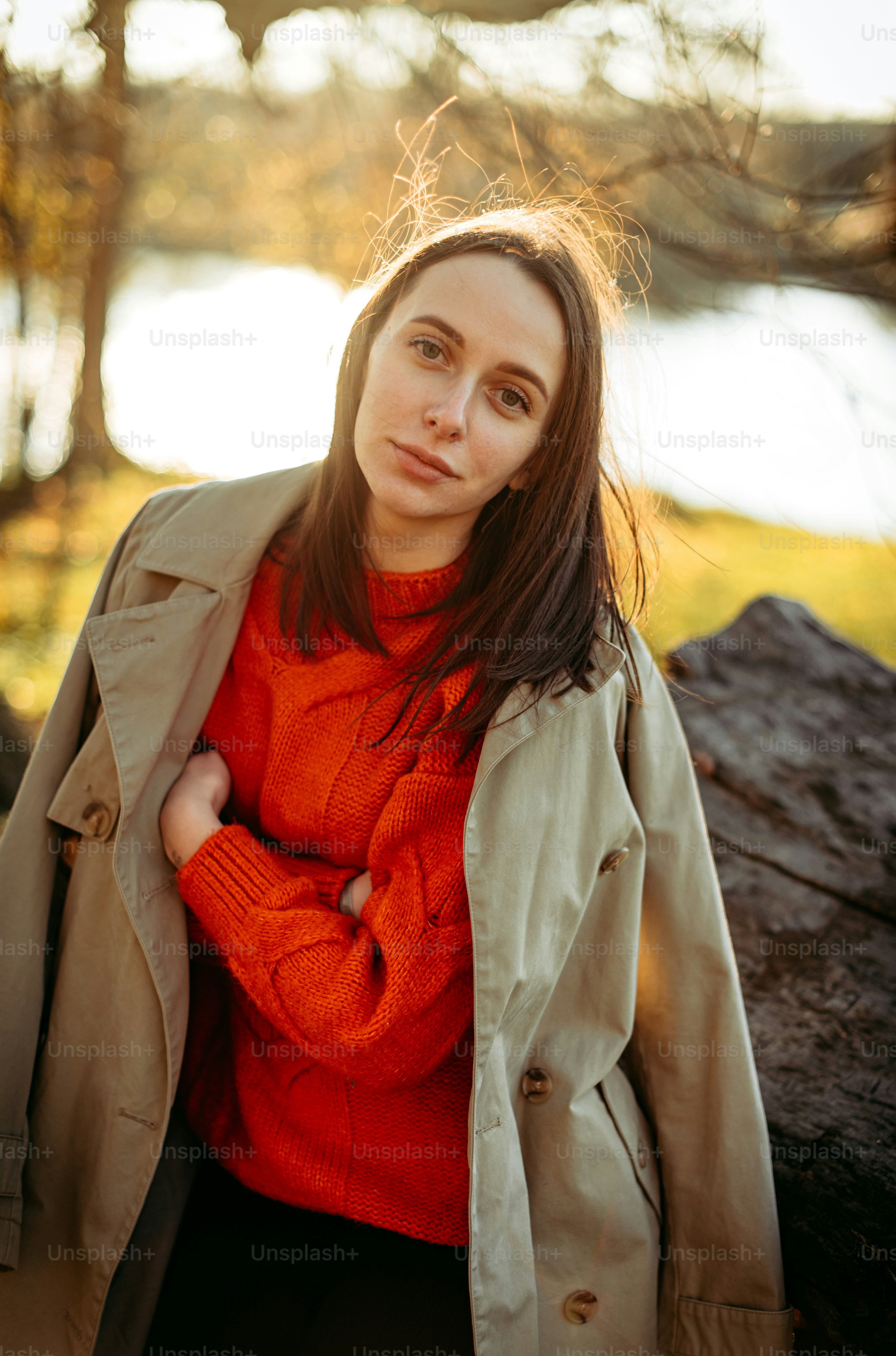 A woman in an orange sweater and trench coat photo – Profile Image on ...