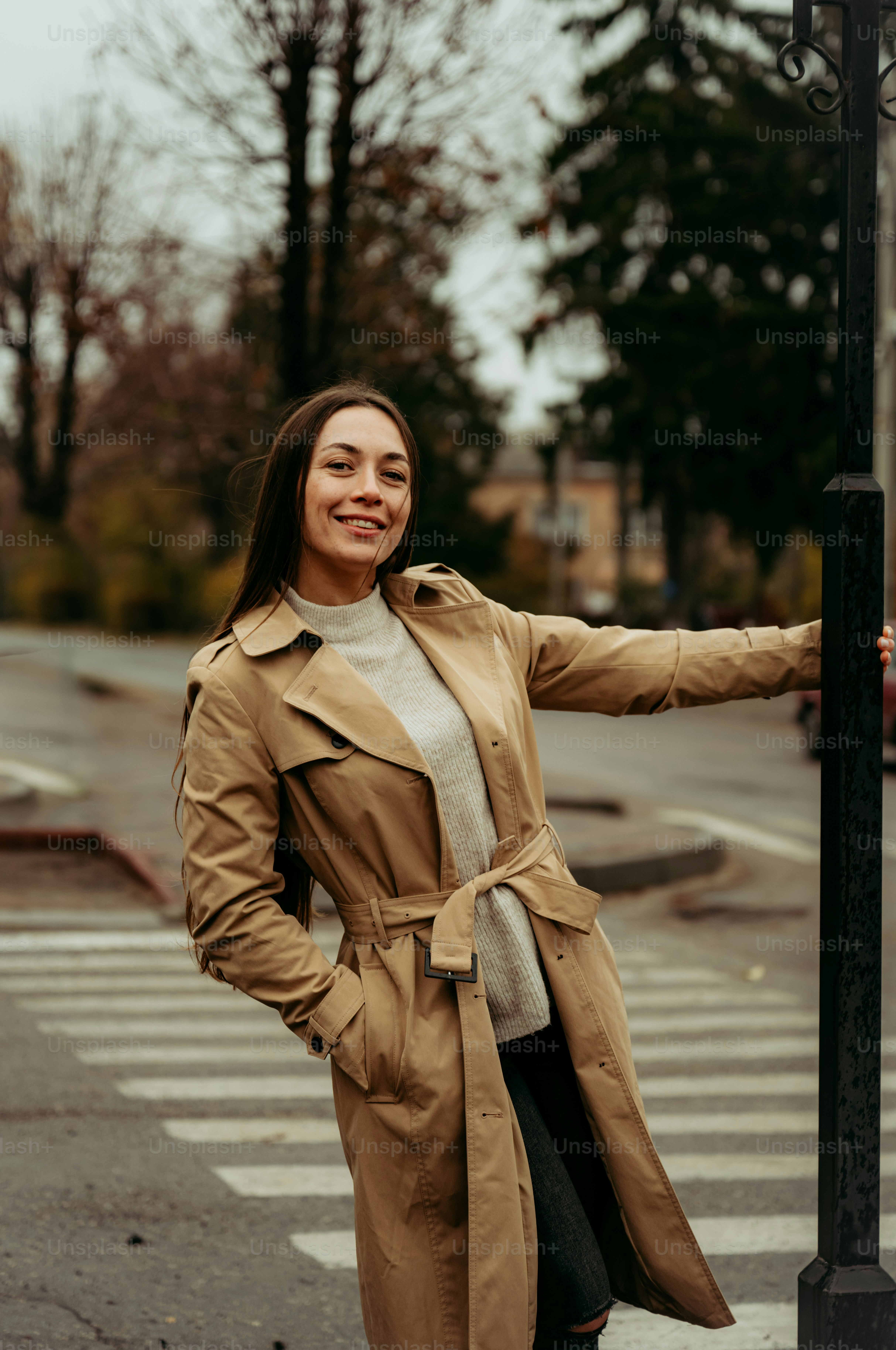 A woman standing next to a street light