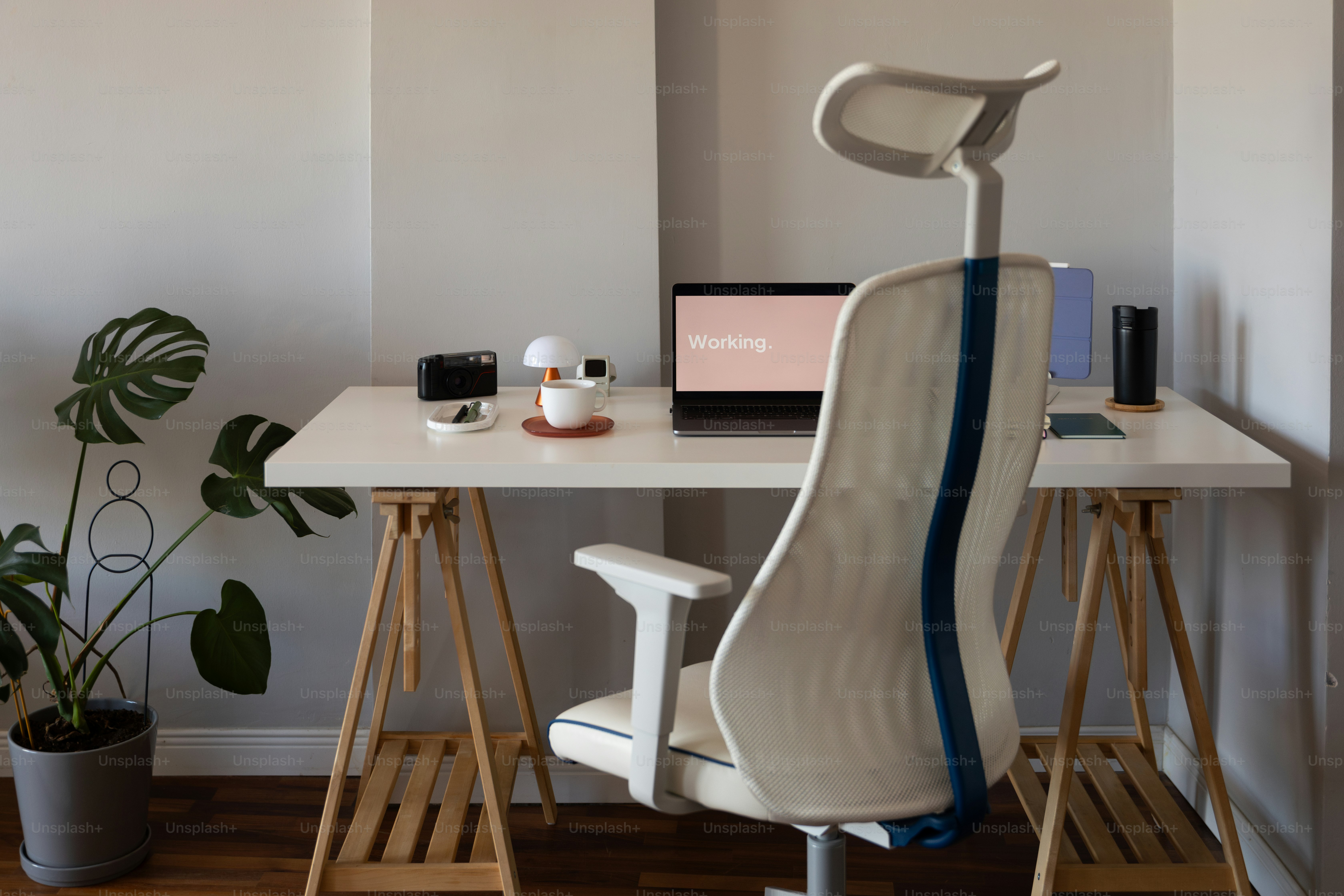 A white desk with a laptop and a chair