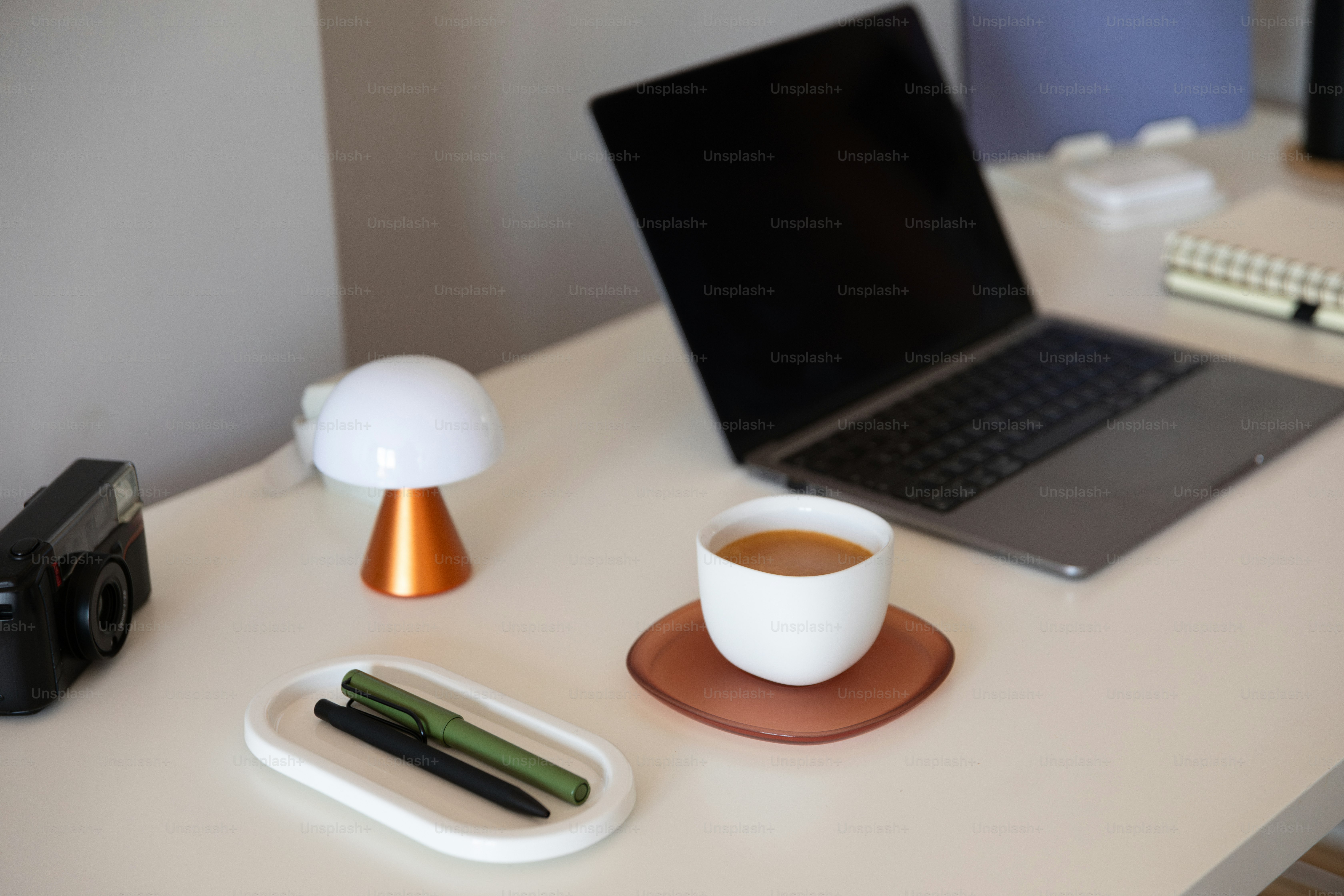 A laptop computer sitting on top of a desk next to a cup of coffee