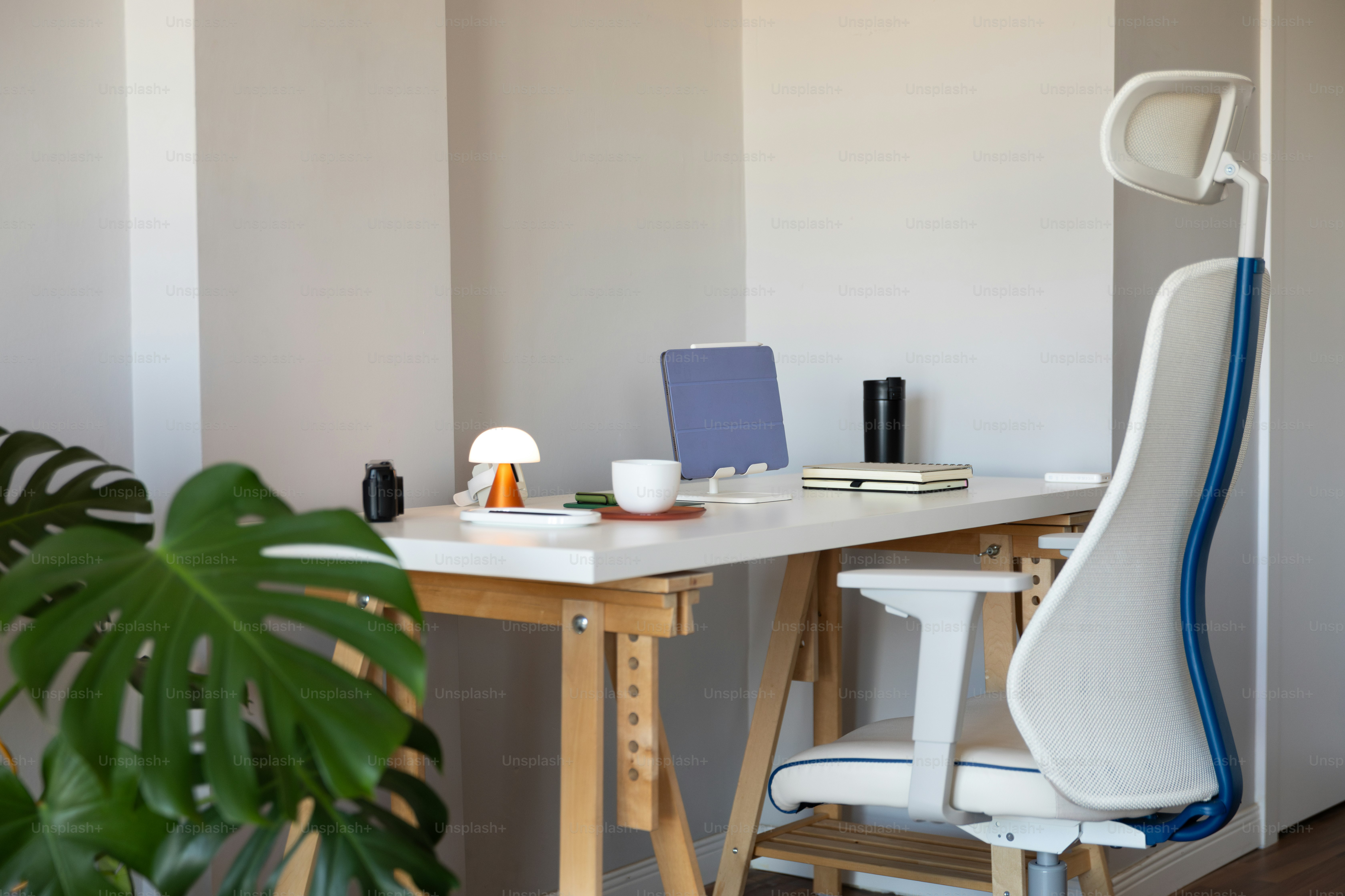 A room with a table and a chair with a laptop on it