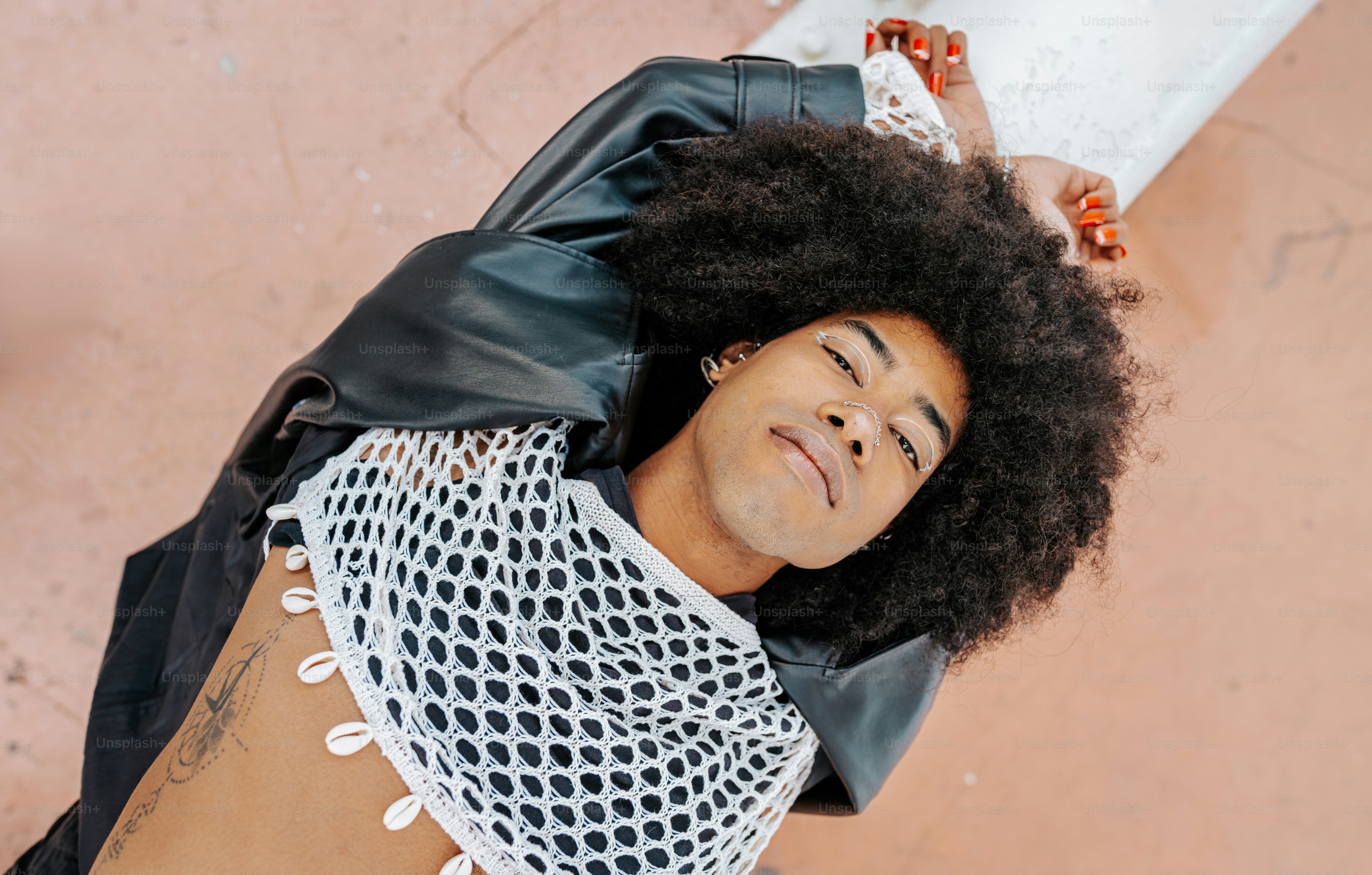 A man laying on the ground wearing a black jacket