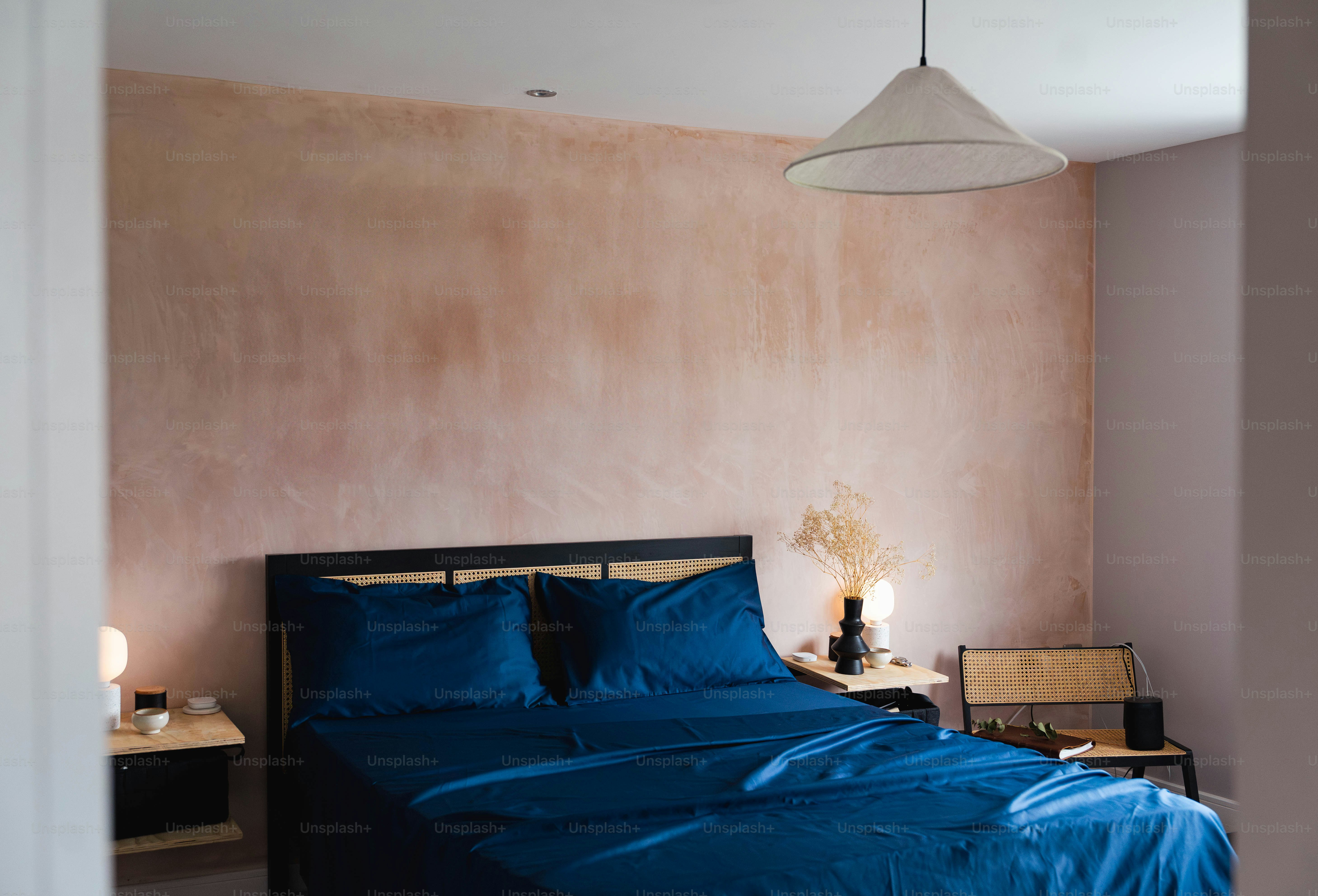 Un lit avec une couette bleue dans une chambre