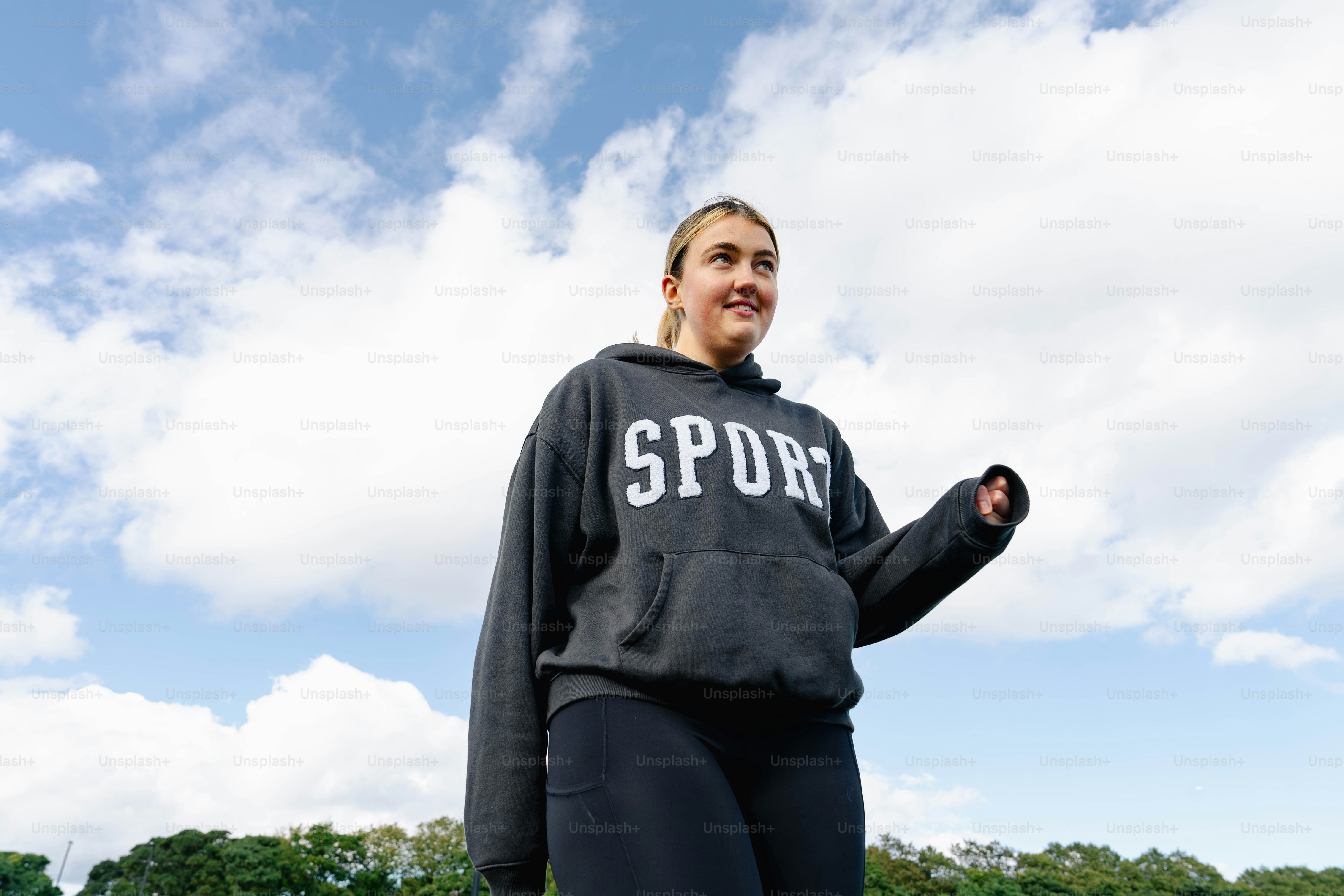 Seorang wanita berdiri di ladang dengan frisbee