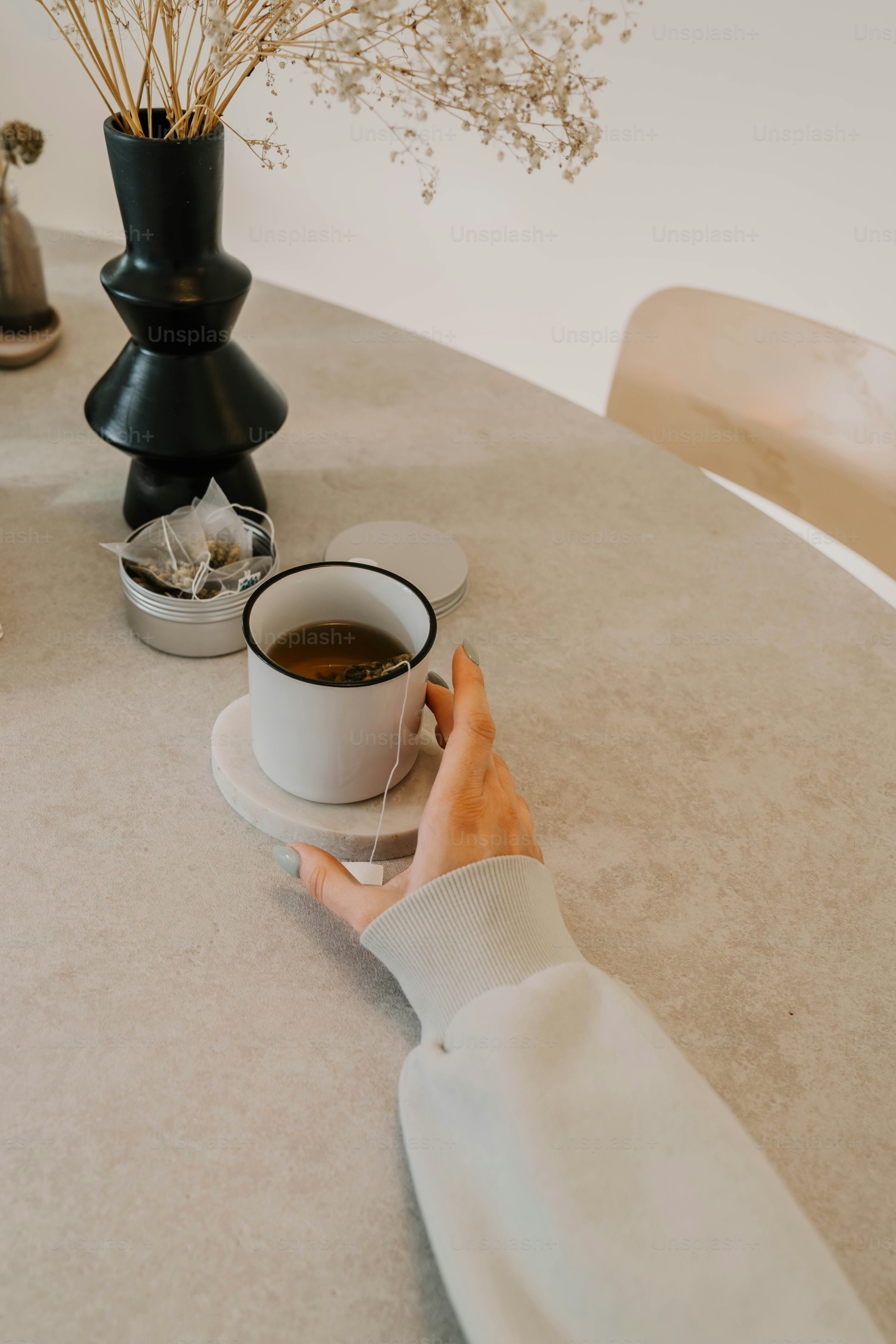 Seseorang duduk di meja dengan secangkir kopi