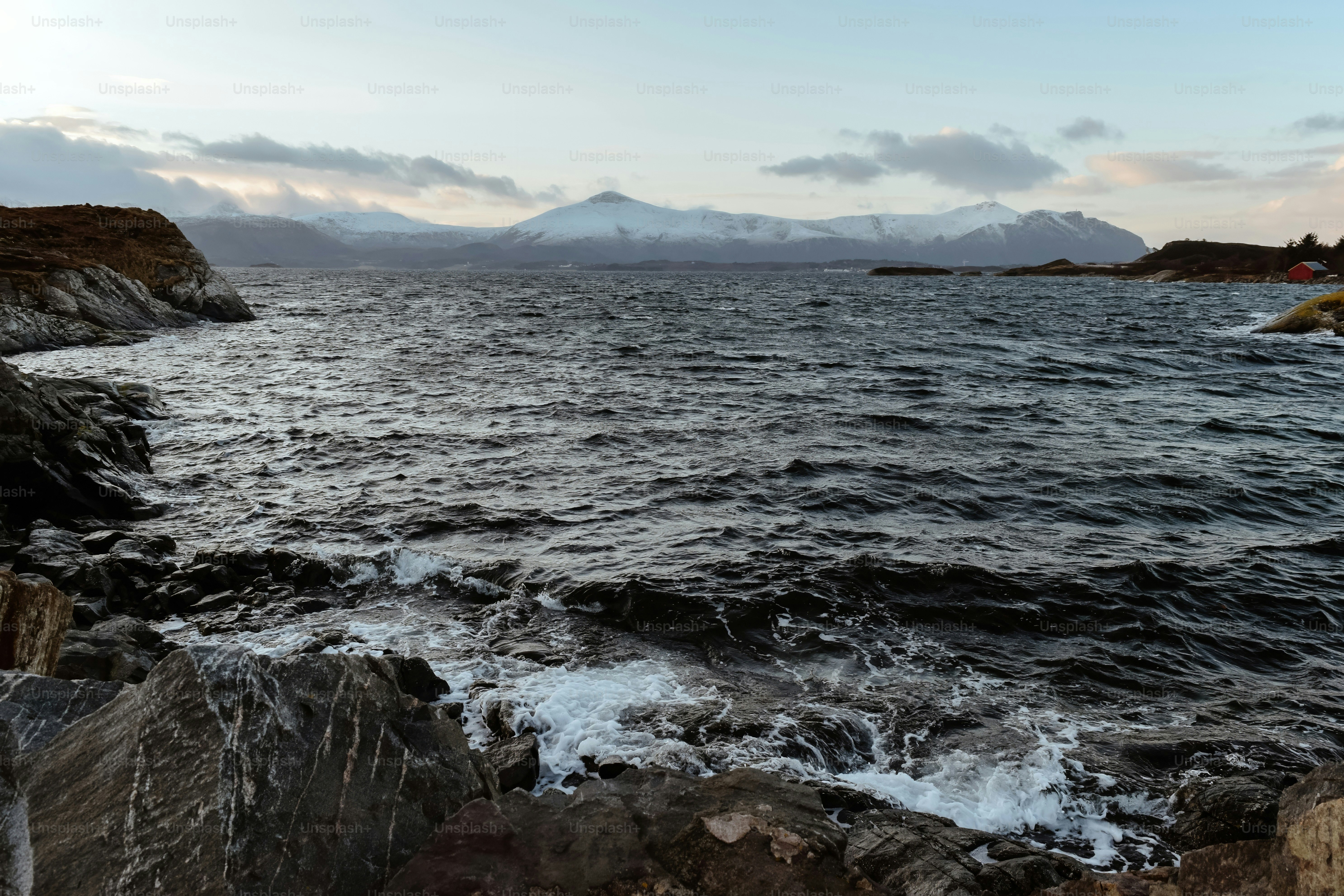 A body of water sitting next to a rocky shore