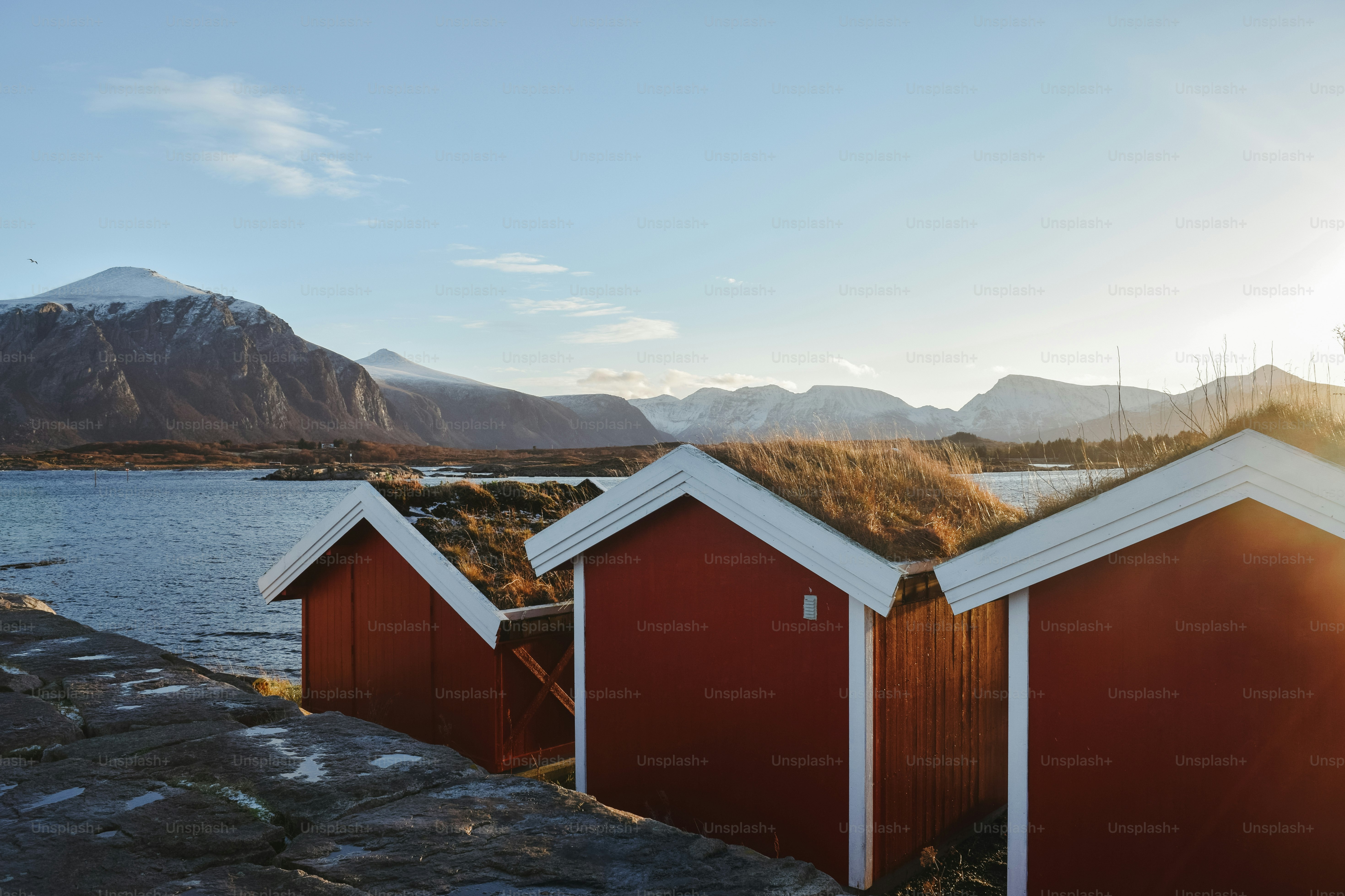 A row of red buildings sitting next to a body of water