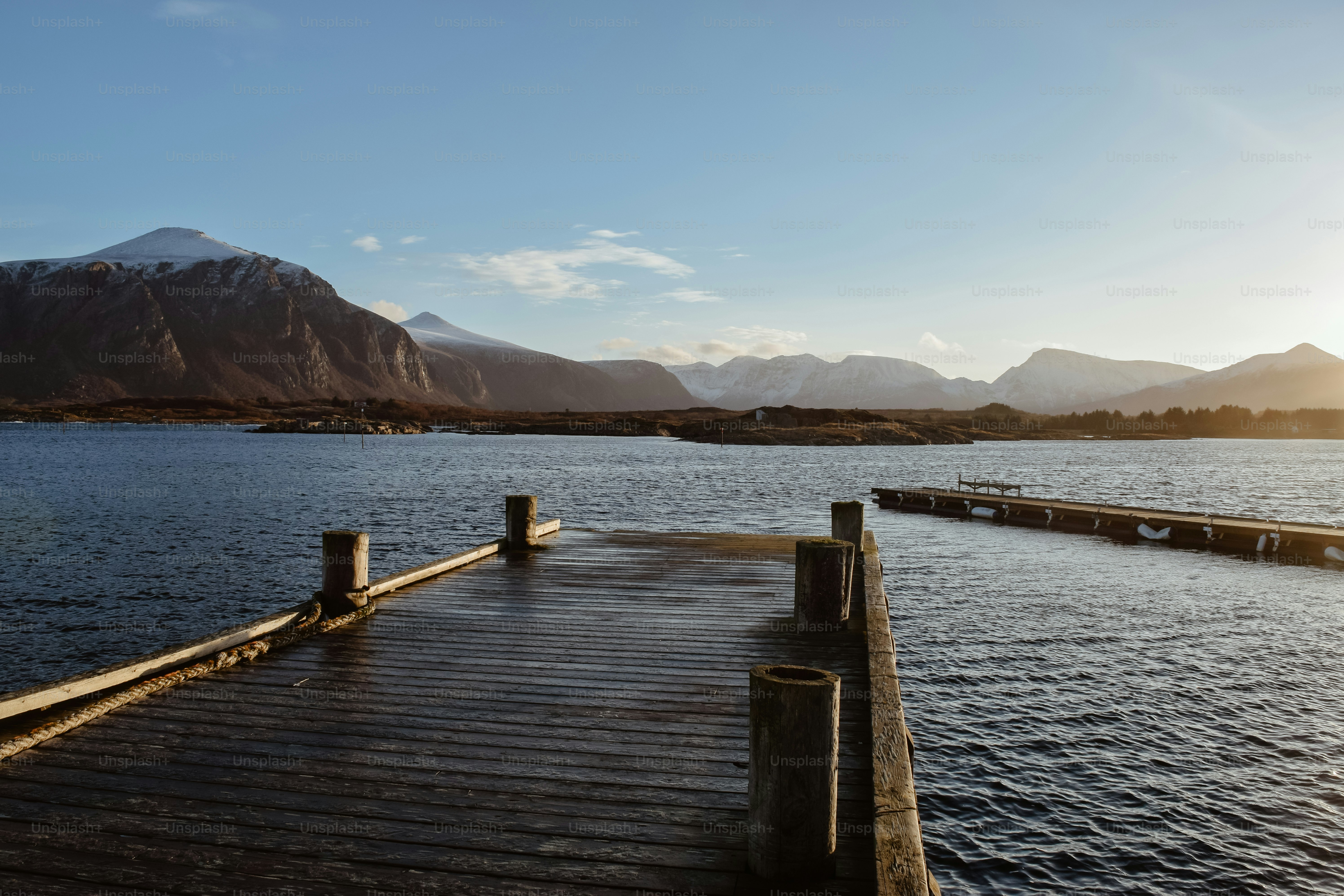 A dock on a lake with mountains in the background