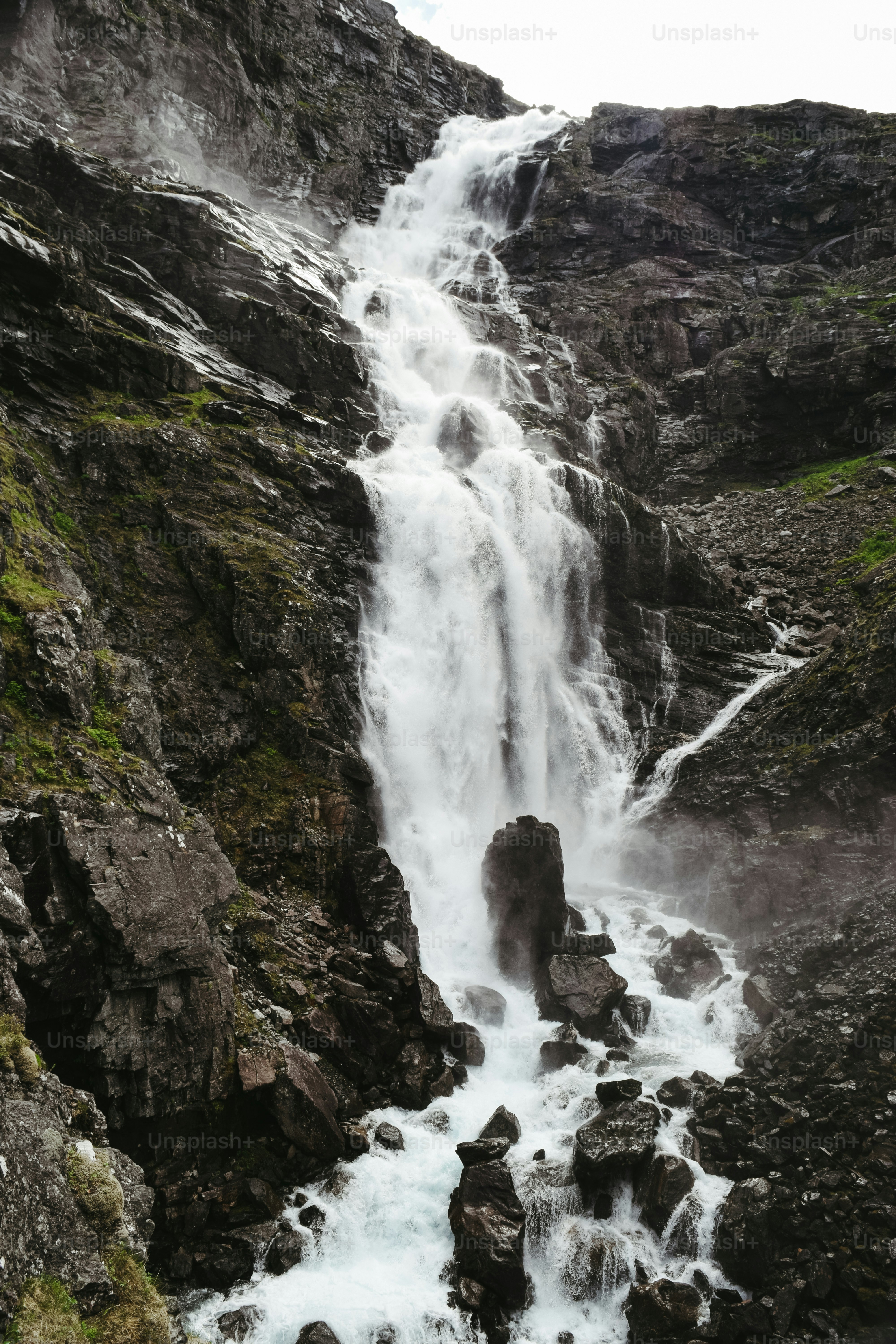A large waterfall is coming down the side of a mountain