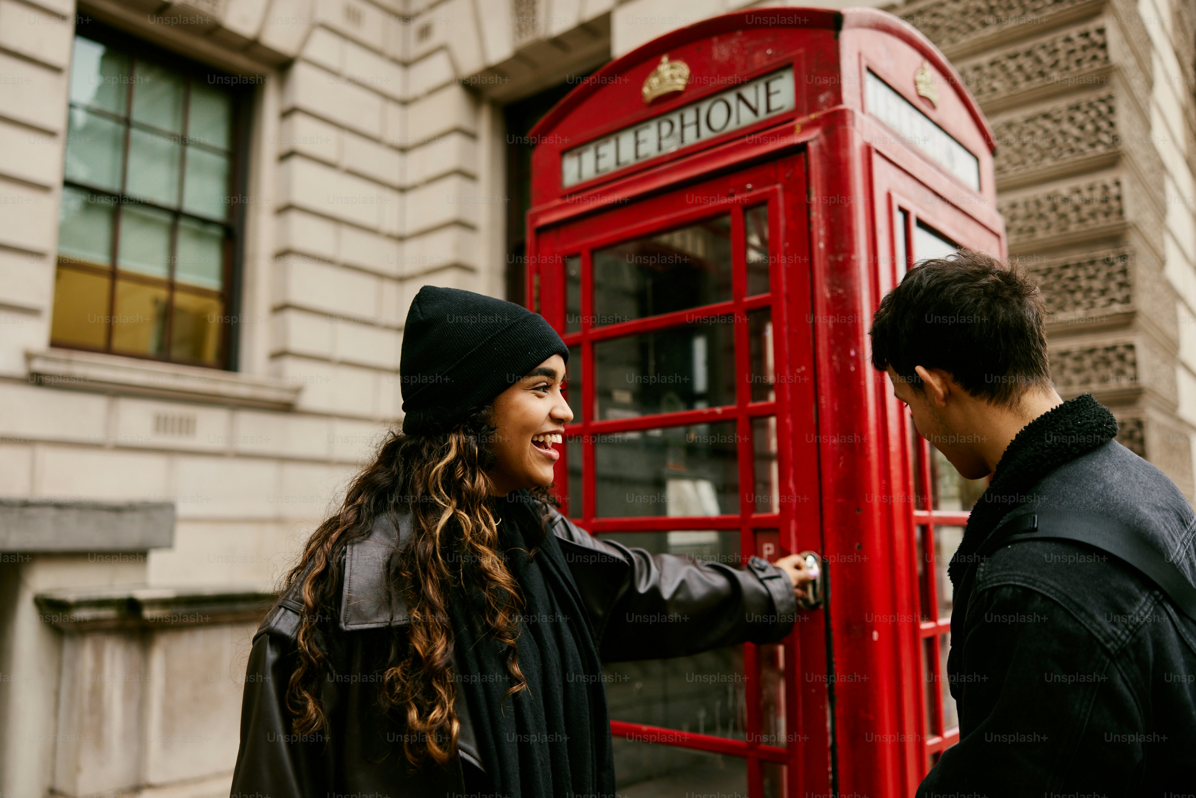 Ein Mann und eine Frau stehen vor einer roten Telefonzelle