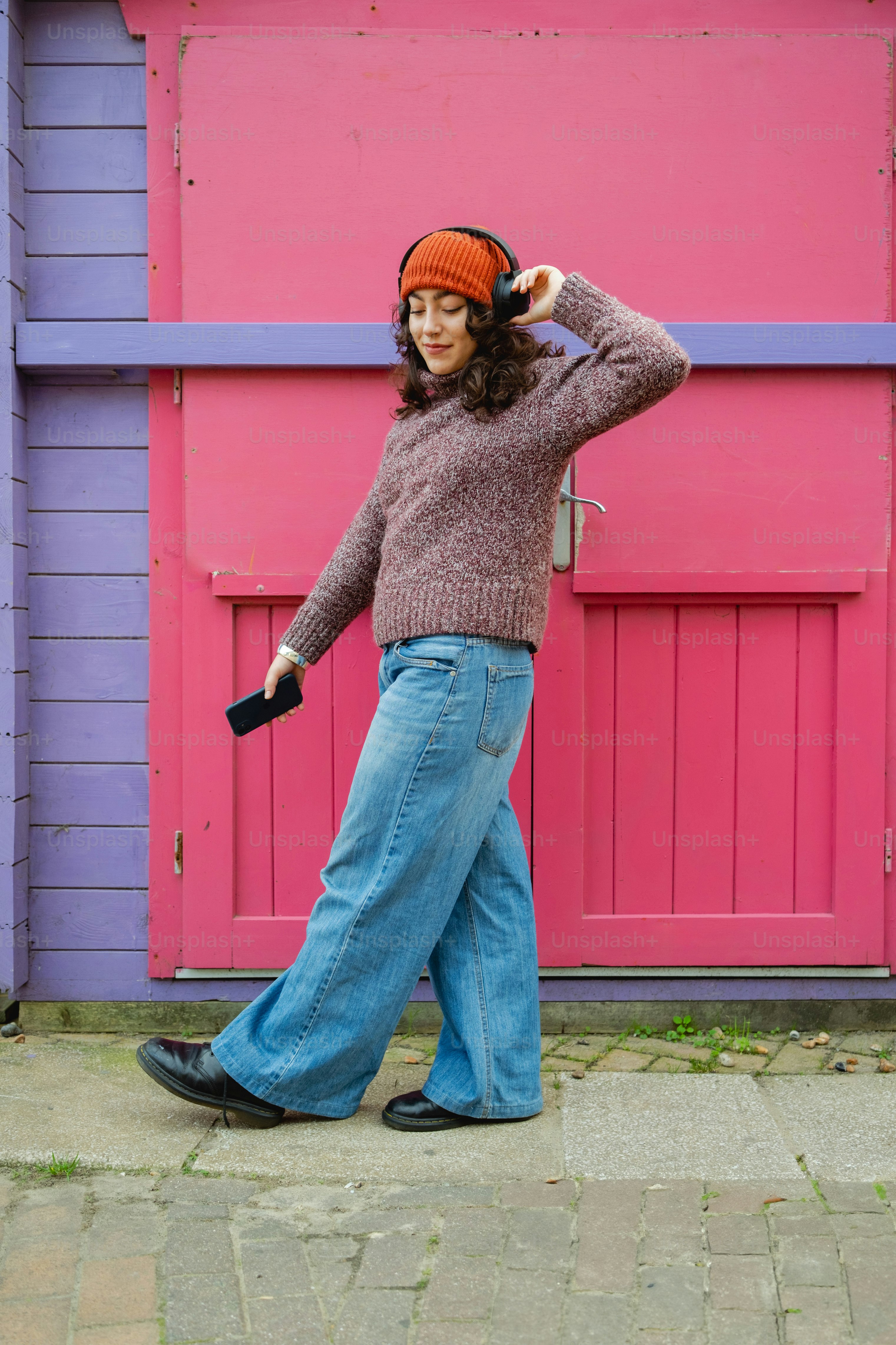 A woman walking down a sidewalk while talking on a cell phone