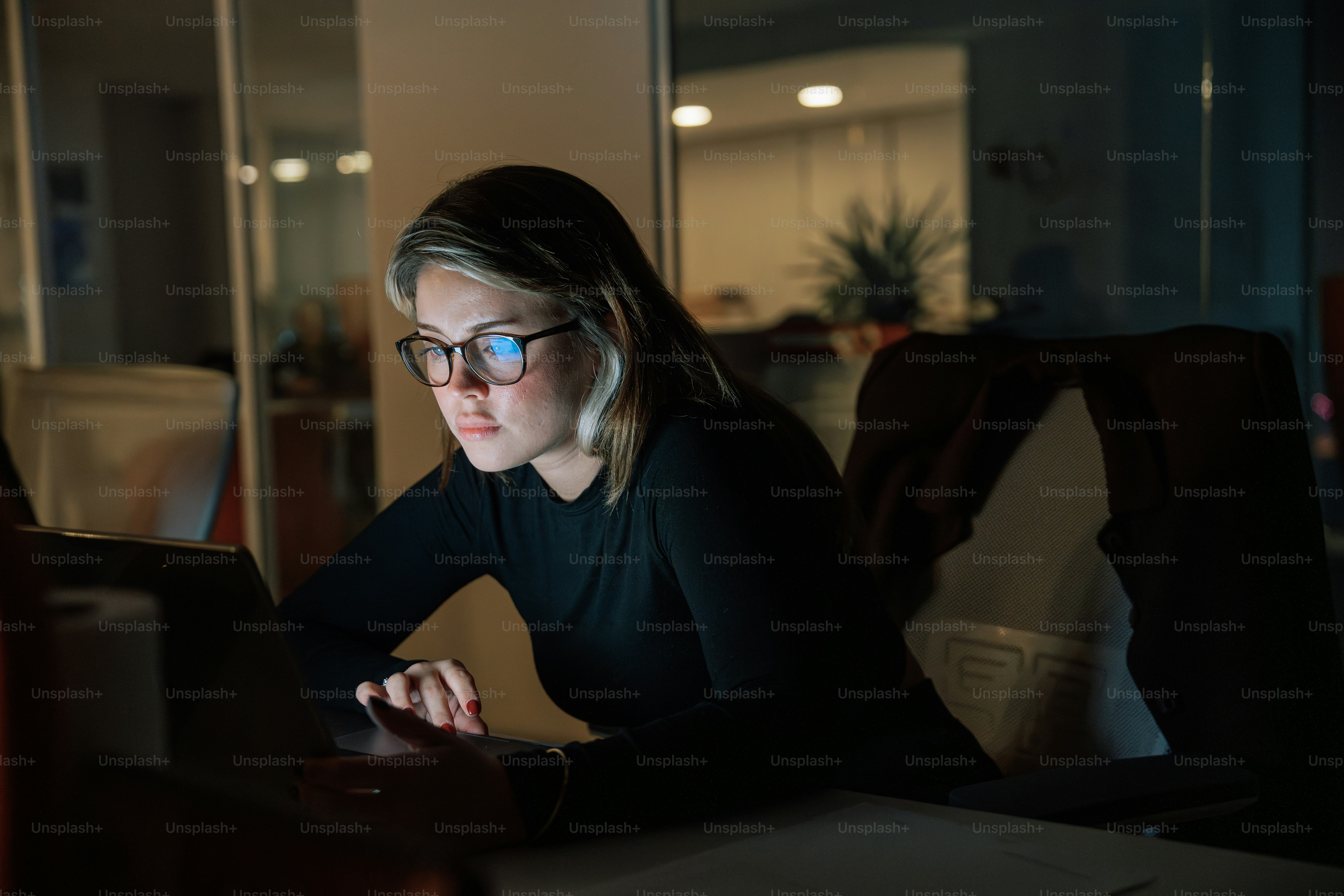A woman sitting in front of a laptop computer photo – Night at the ...