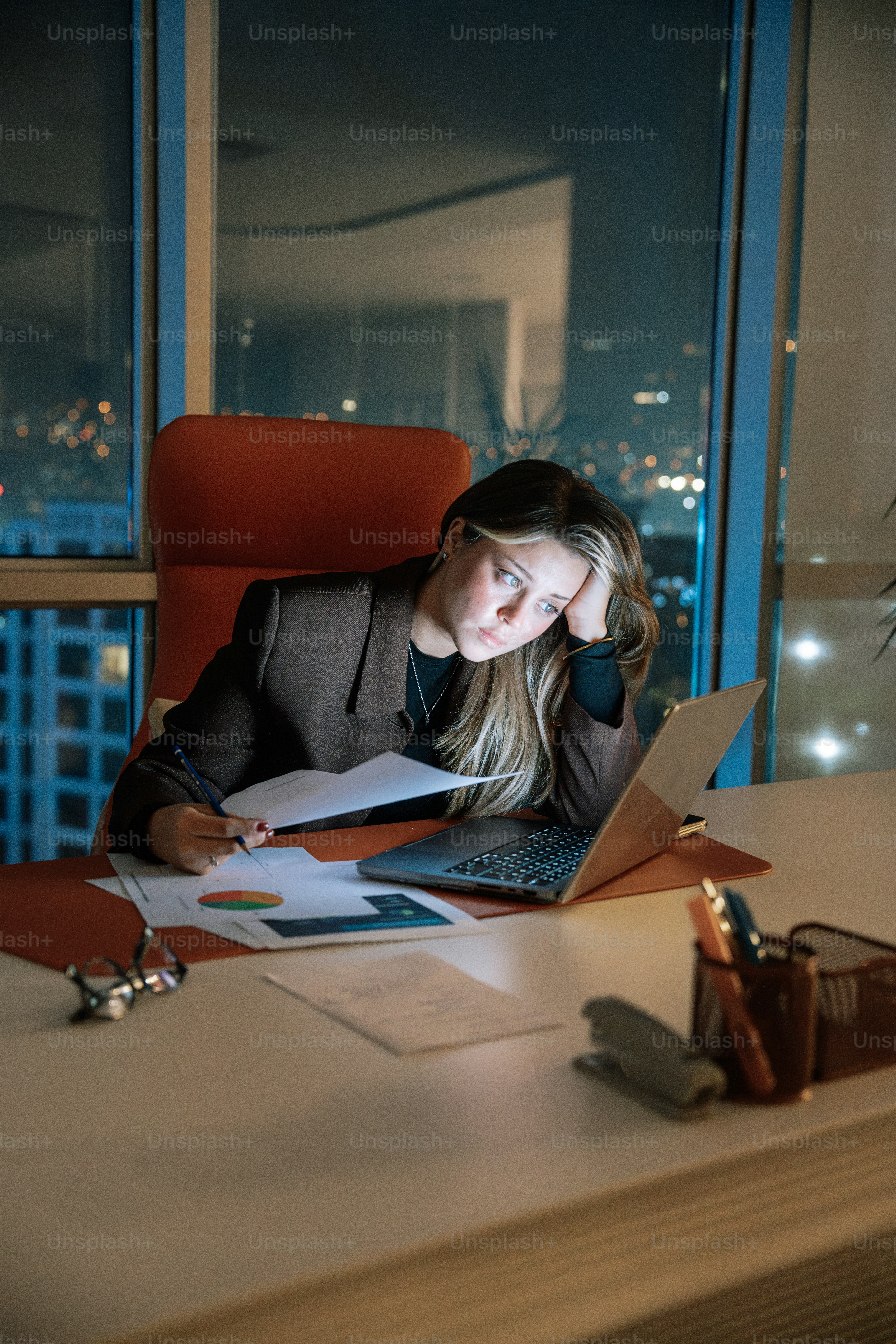Eine Frau, die an einem Schreibtisch vor einem Laptop sitzt