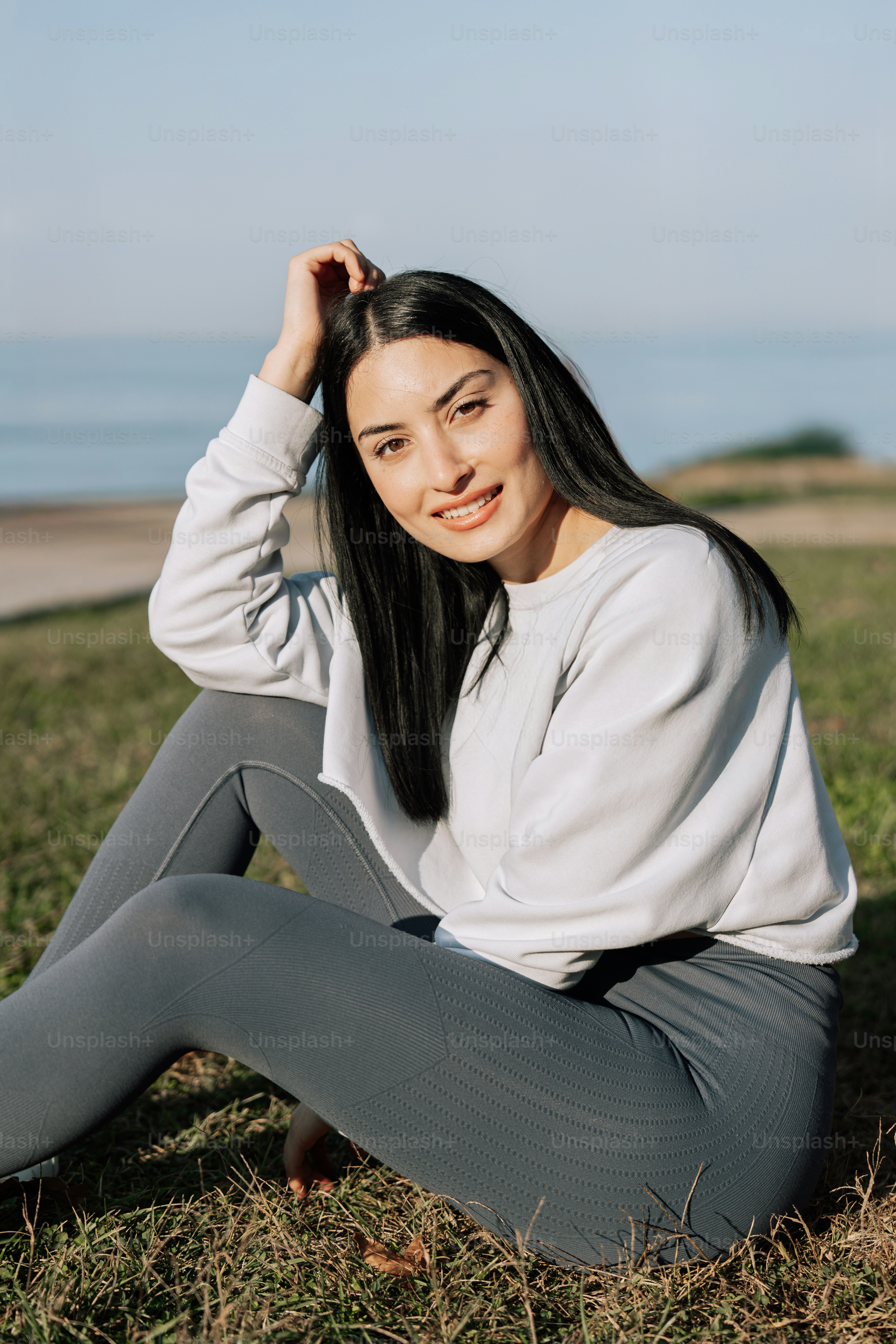 A woman sitting on the ground in a field