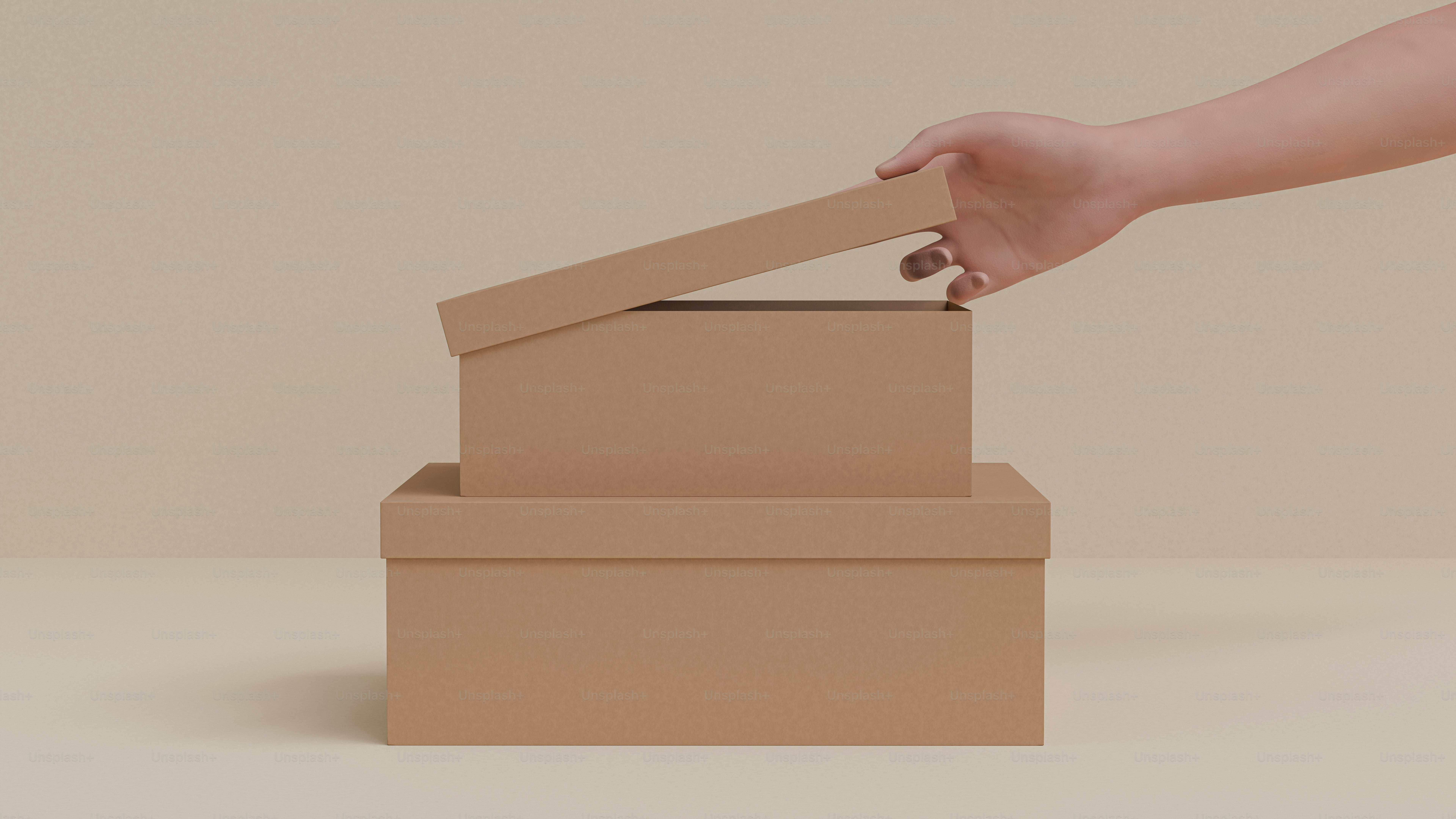 A hand reaching for a cardboard box on a table