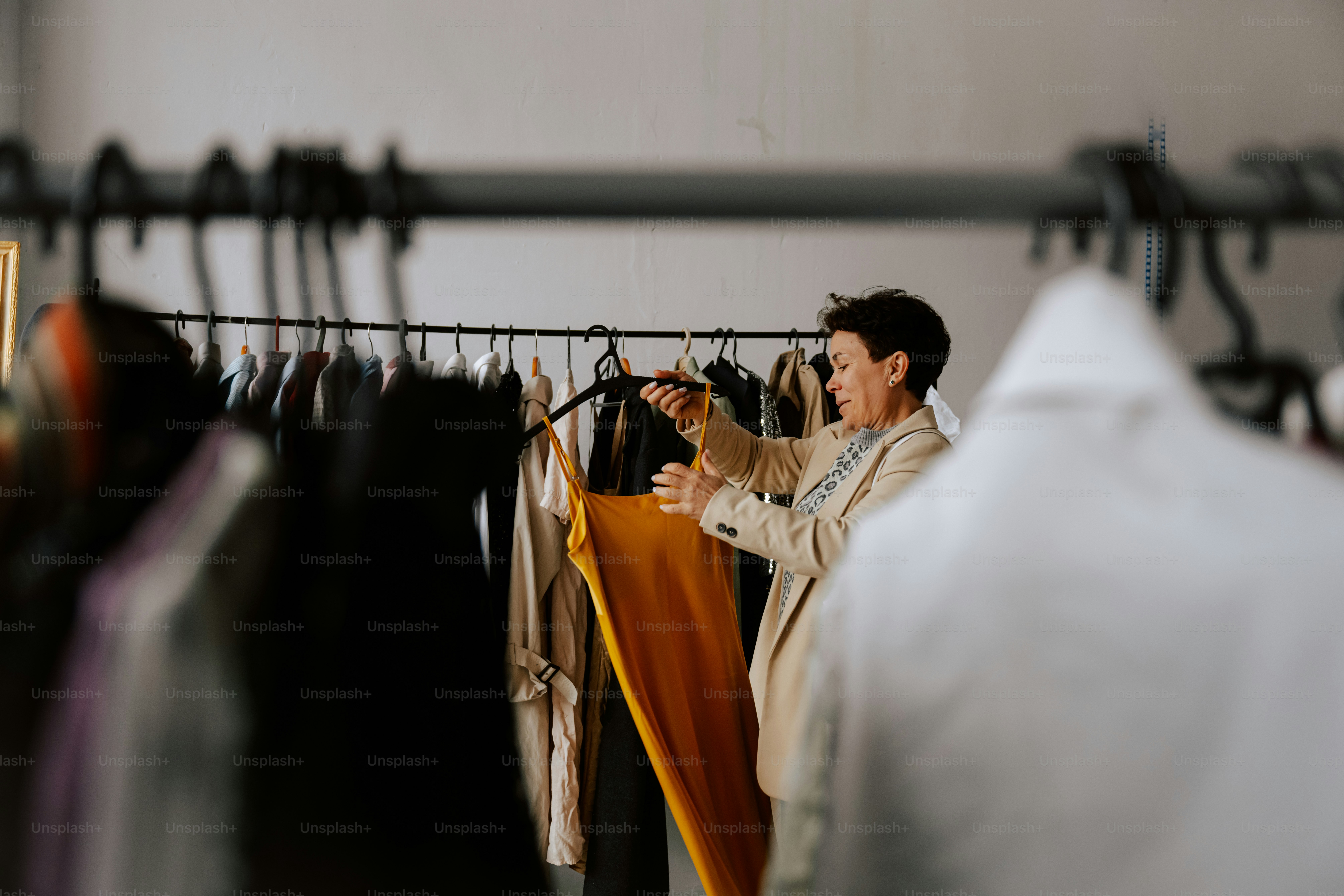 A man taking a picture of a shirt hanging on a rack