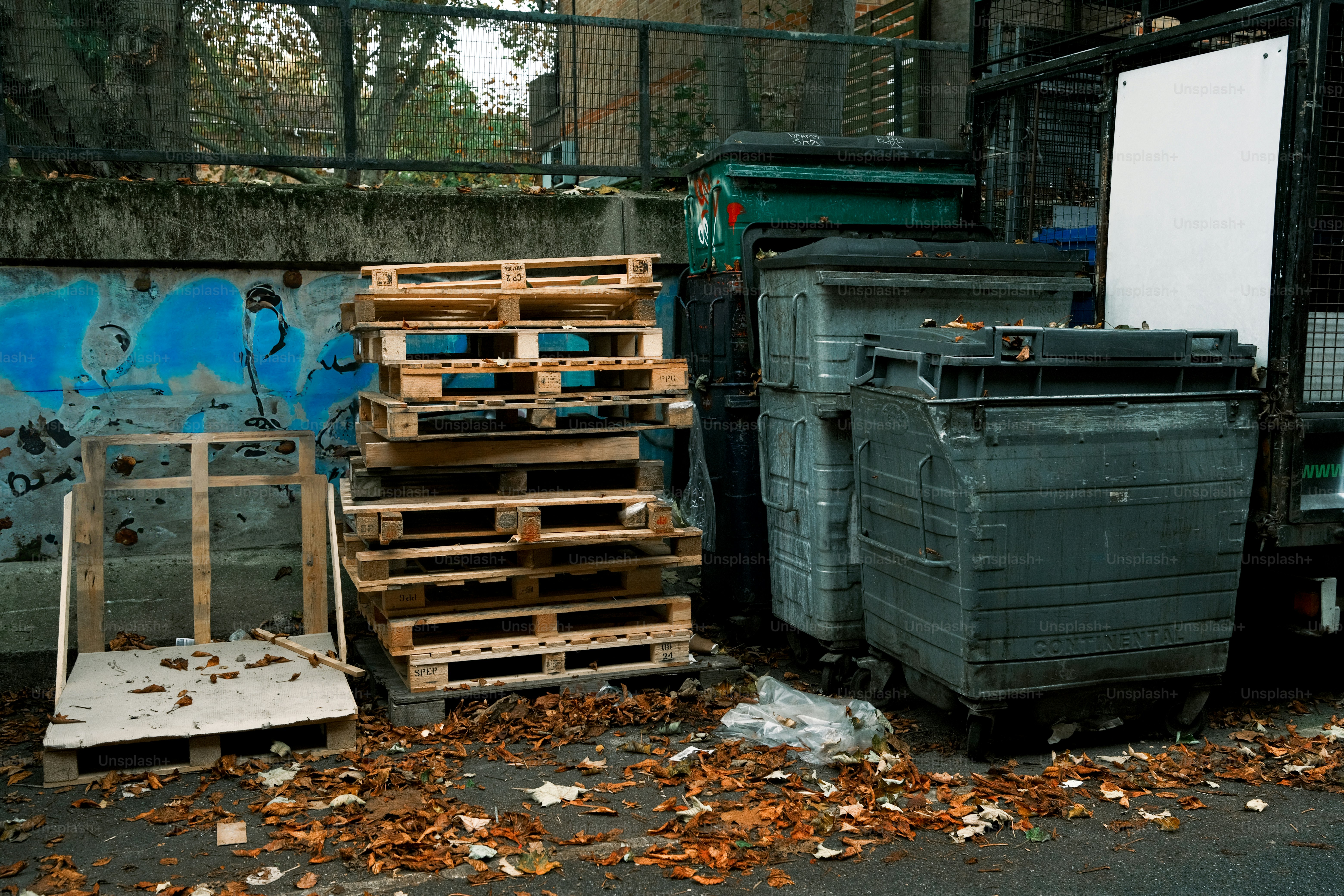 A pile of wooden pallets sitting next to a building