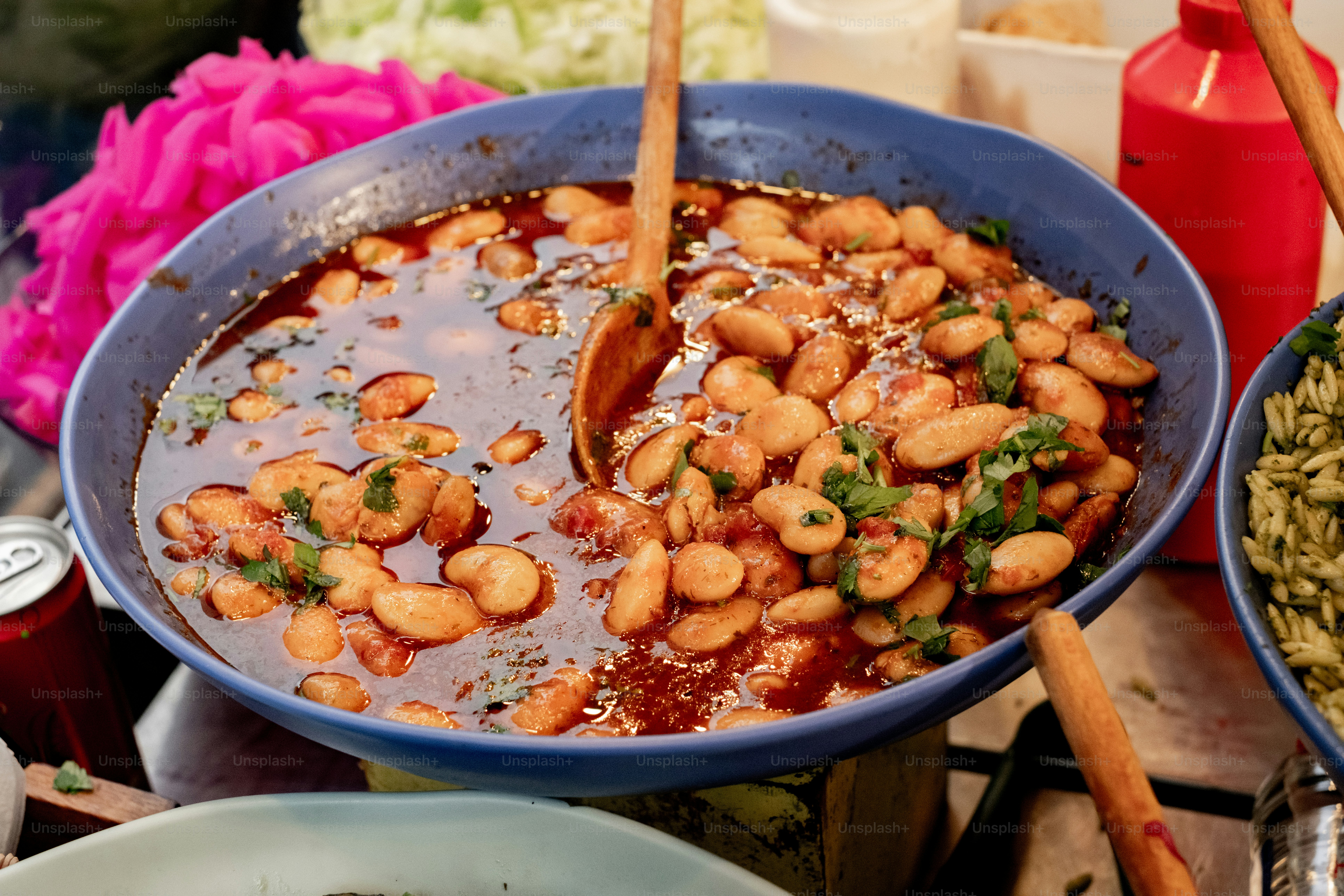 Una mesa cubierta con cuencos de comida y una cuchara de madera