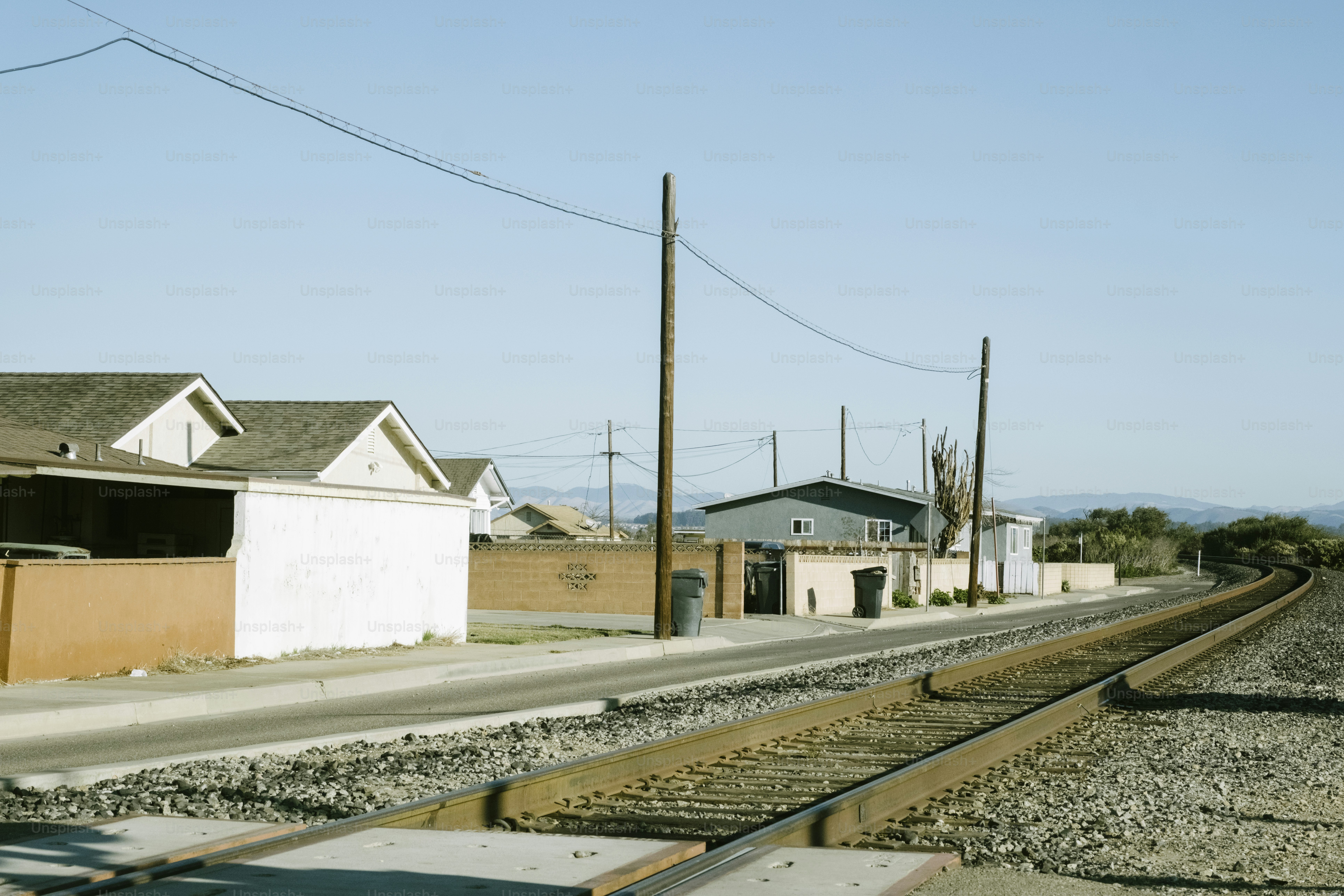 A view of a train track with houses in the background