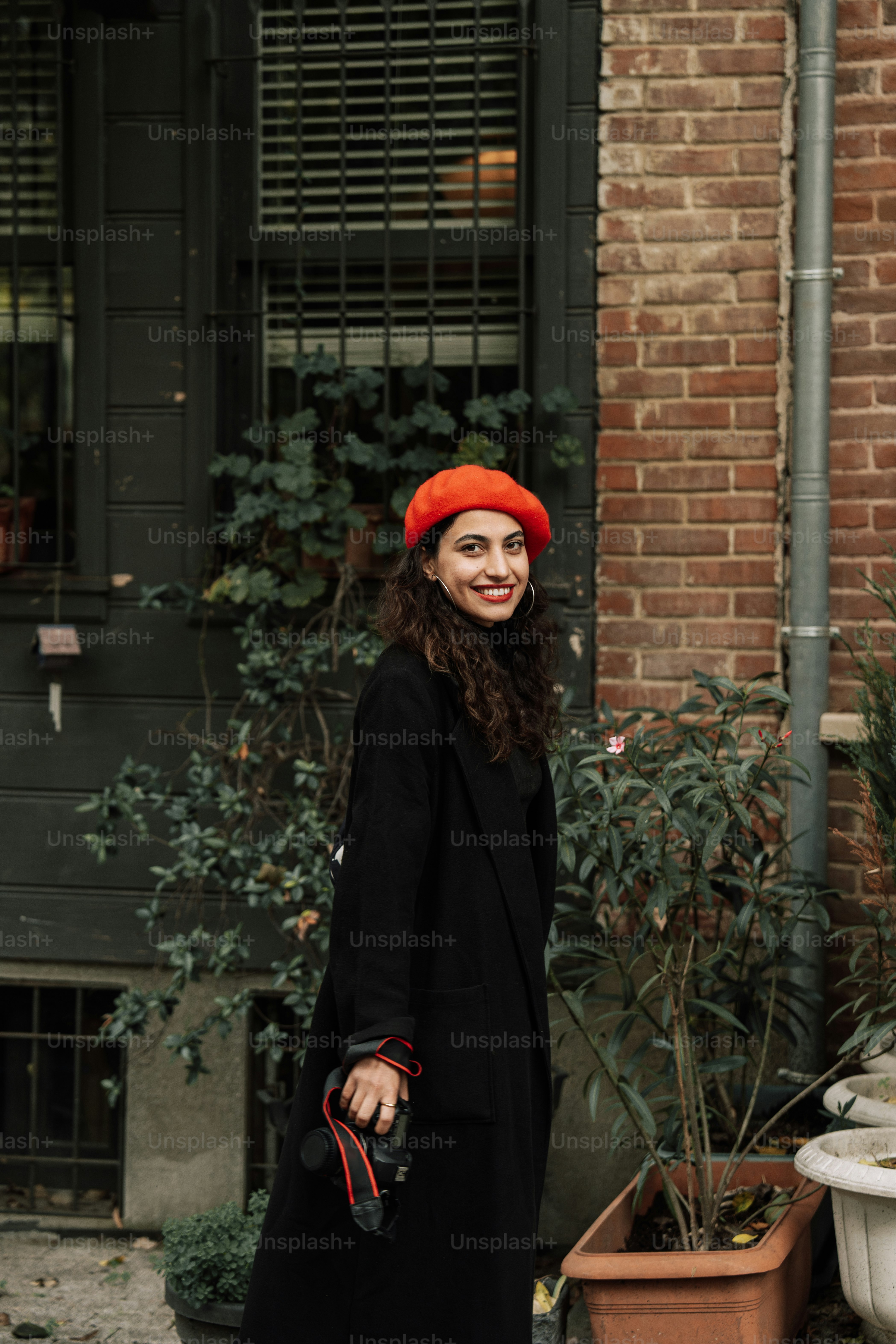 A woman wearing a red hat and black coat