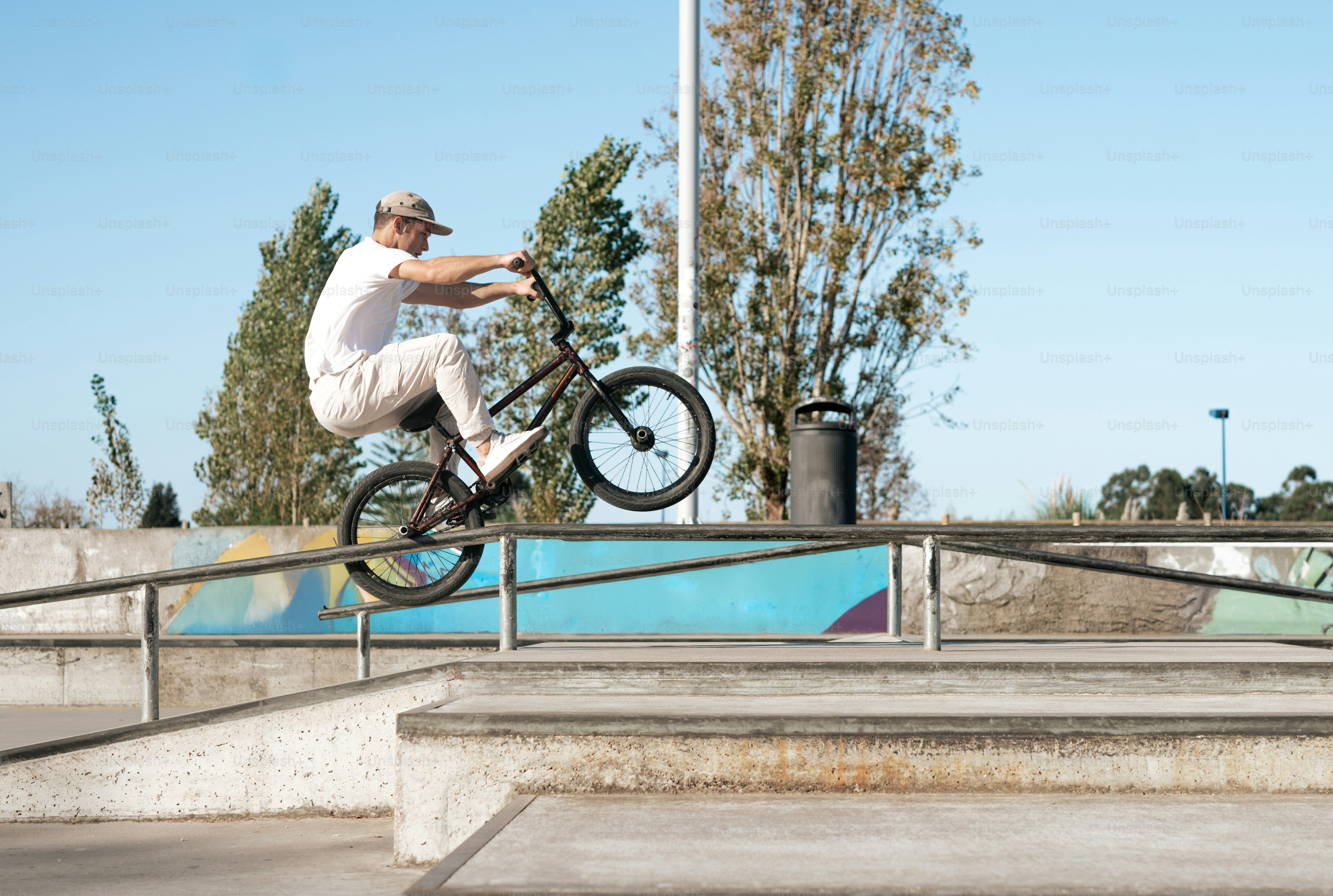 A man riding a bike up the side of a metal rail