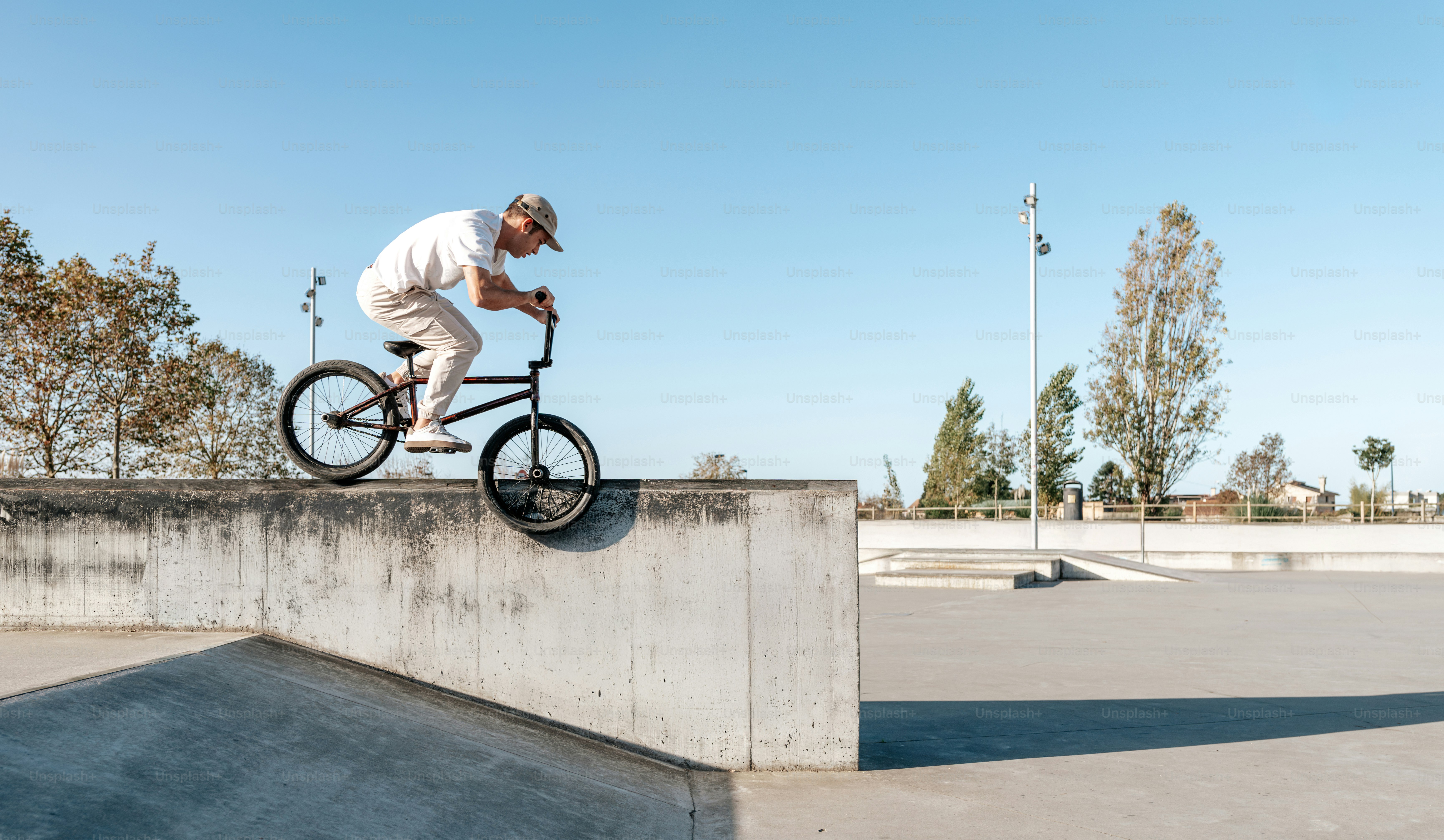A man riding a bike up the side of a cement ramp