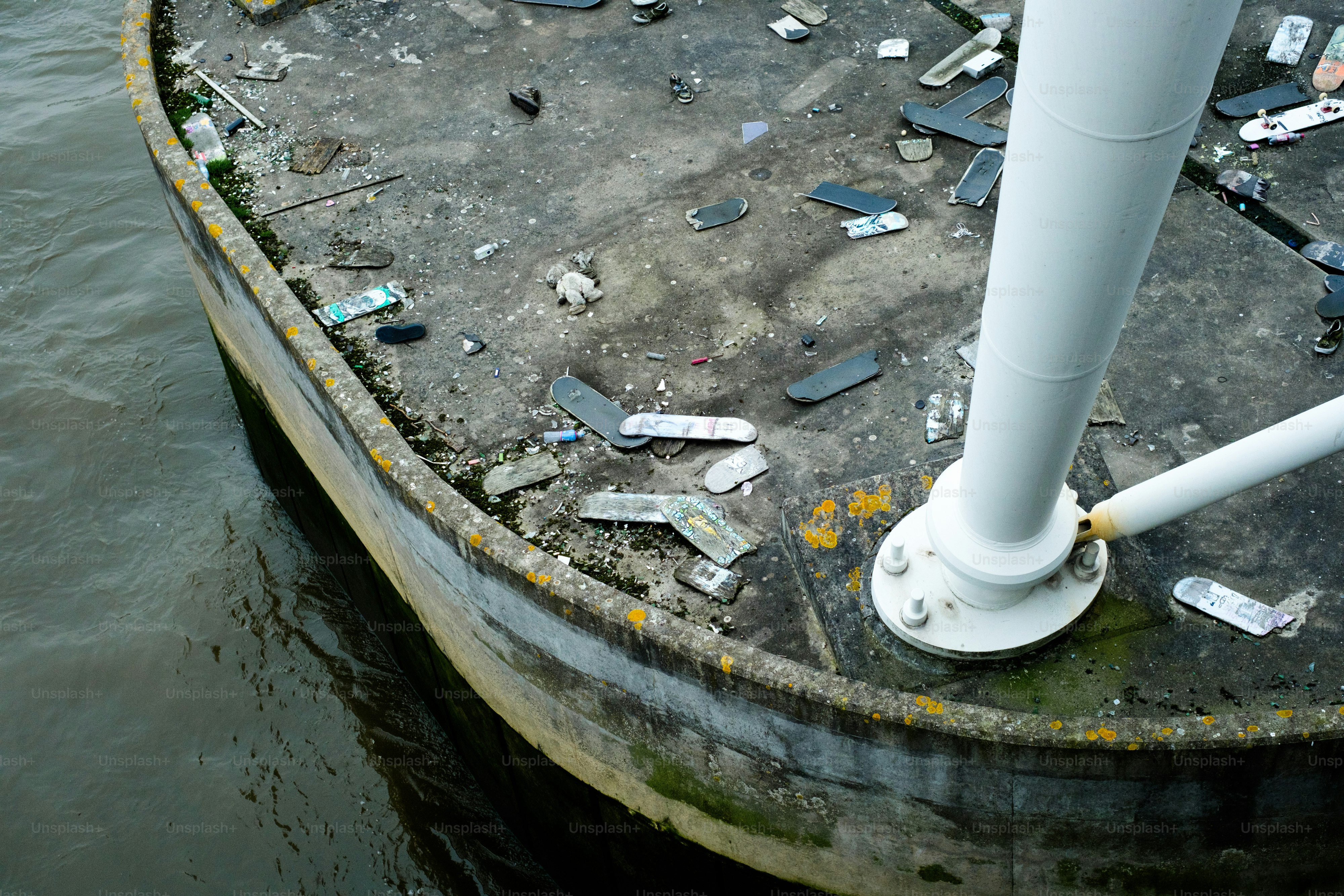 A pipe sticking out of the ground next to a body of water