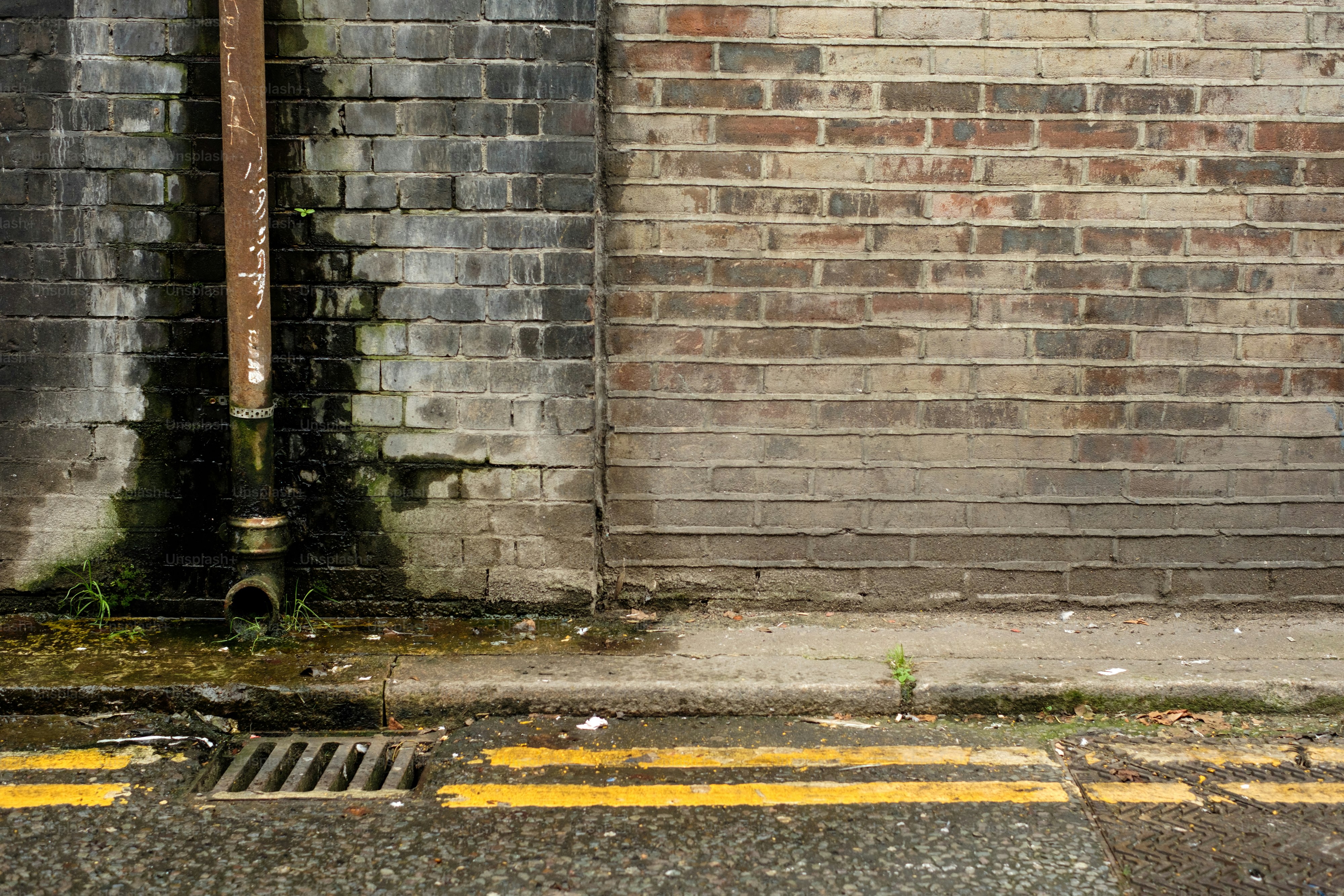 A fire hydrant in front of a brick wall